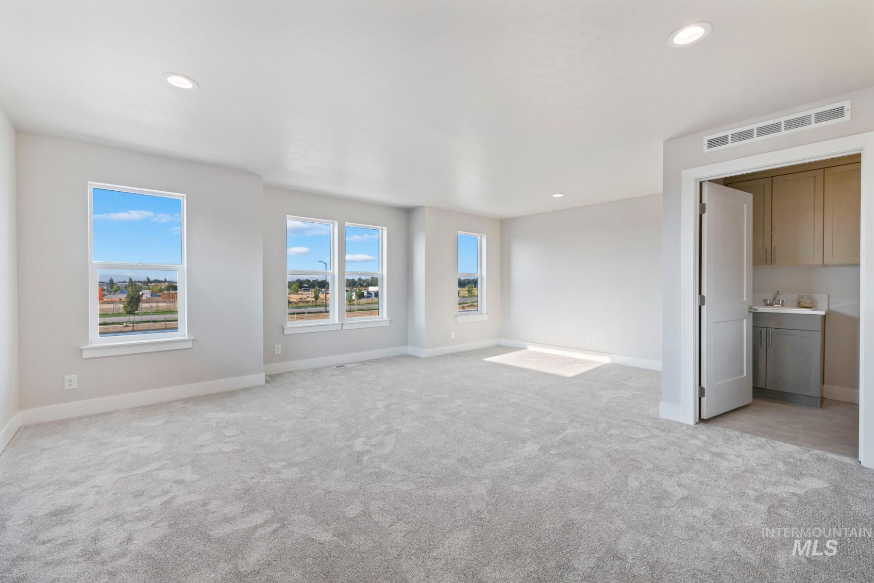 Unfurnished living room with light carpet and recessed lighting