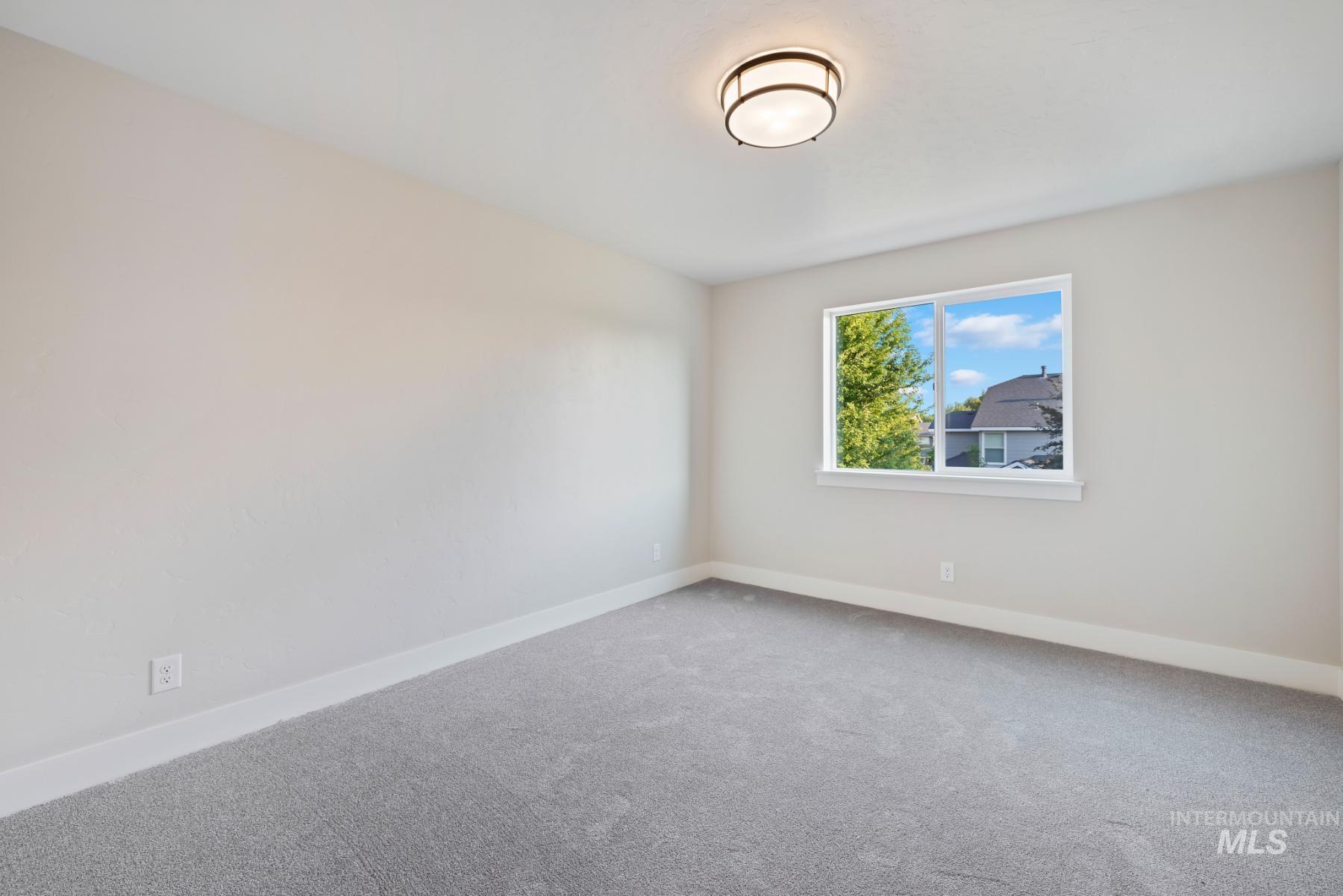 Carpeted empty room with baseboards