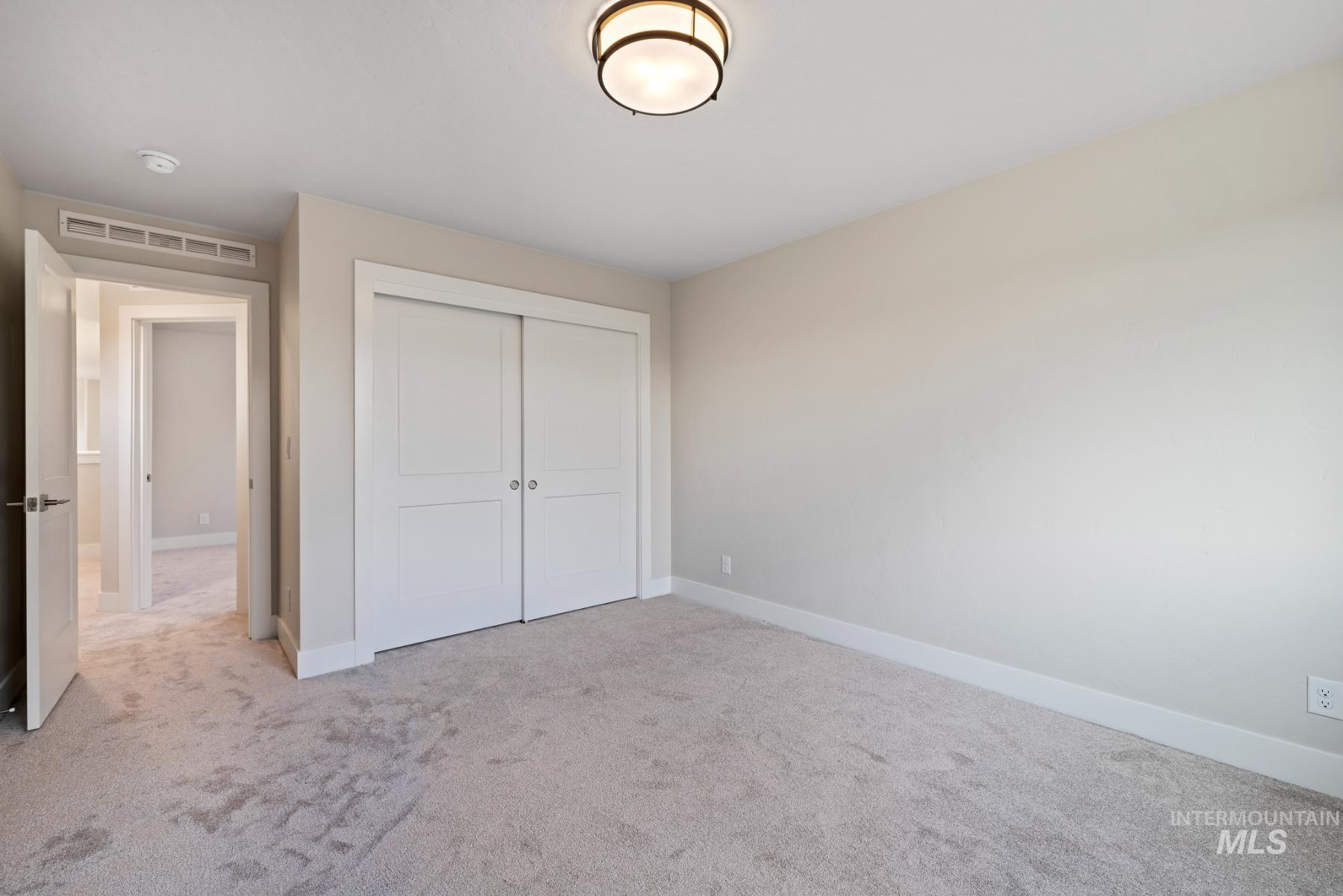 Unfurnished bedroom with light carpet and a closet