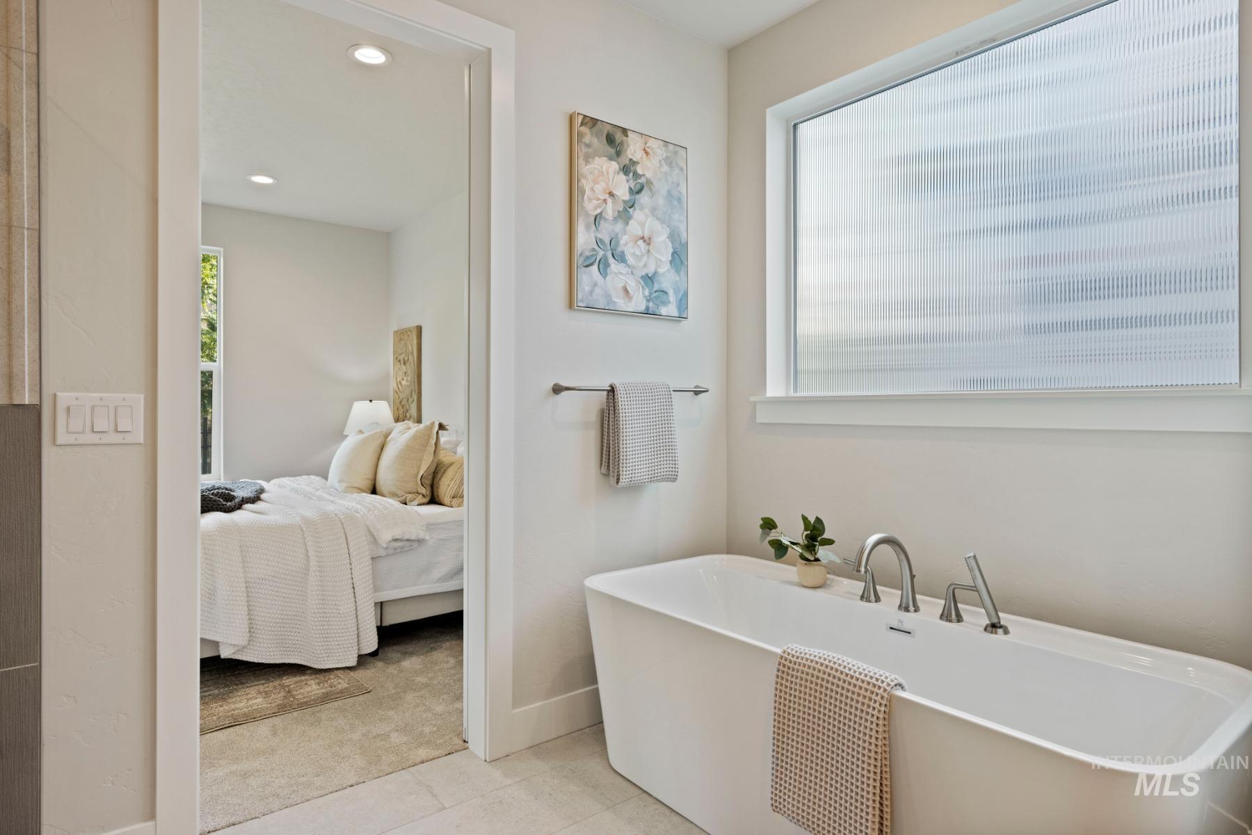 Full bathroom with ensuite bathroom, a freestanding tub, light tile patterned flooring, and recessed lighting