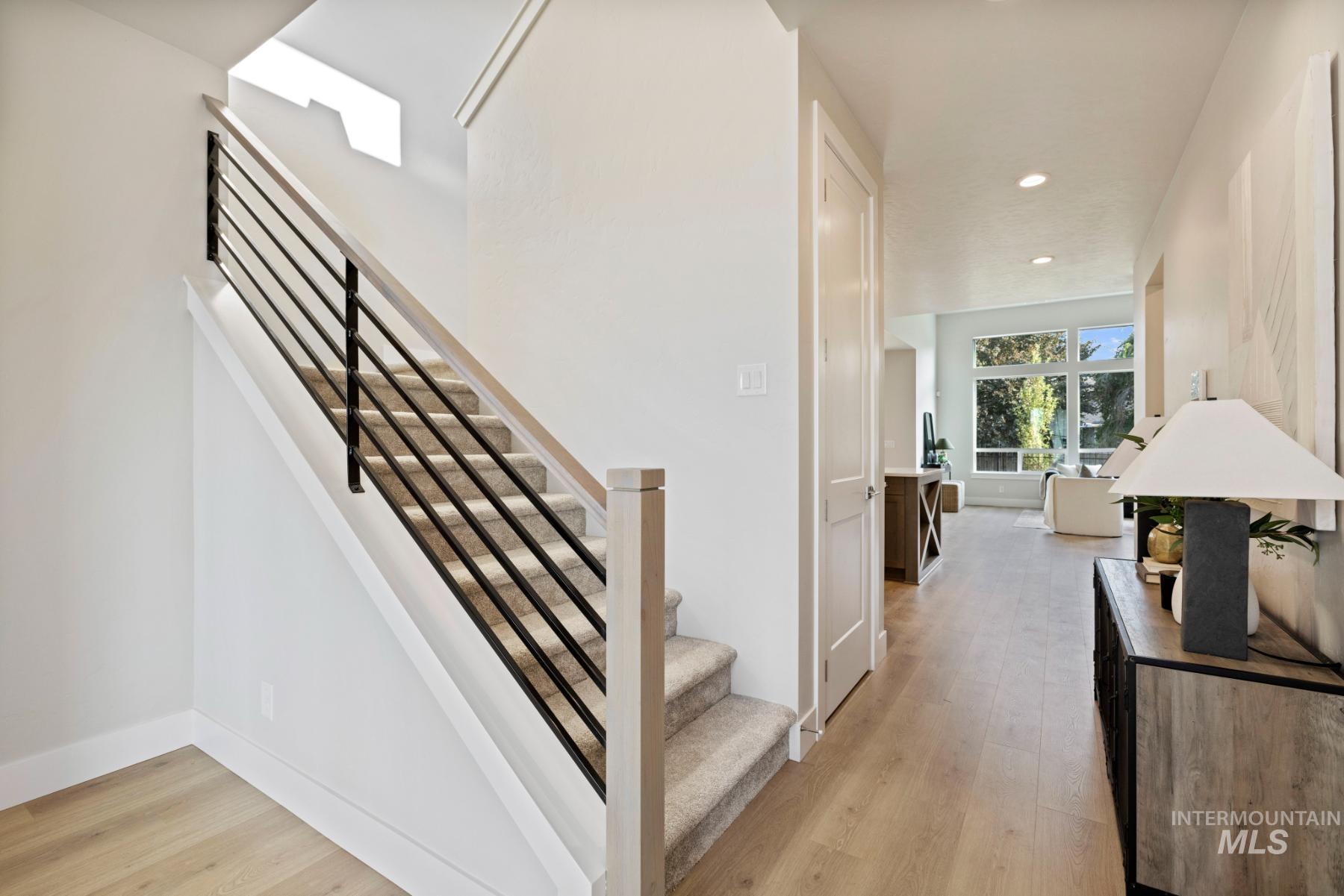 Stairway with wood finished floors and recessed lighting