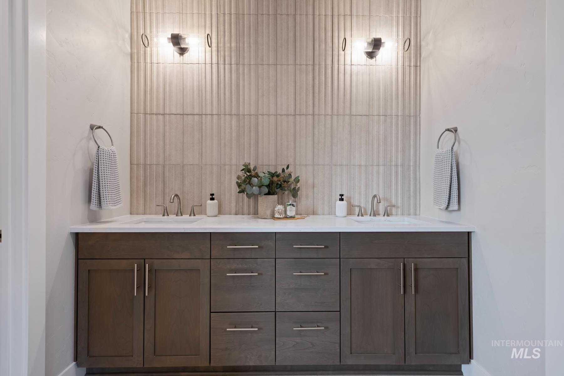 Bathroom with double vanity and baseboards