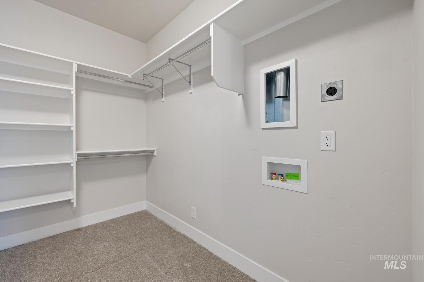 Walk in closet featuring light carpet