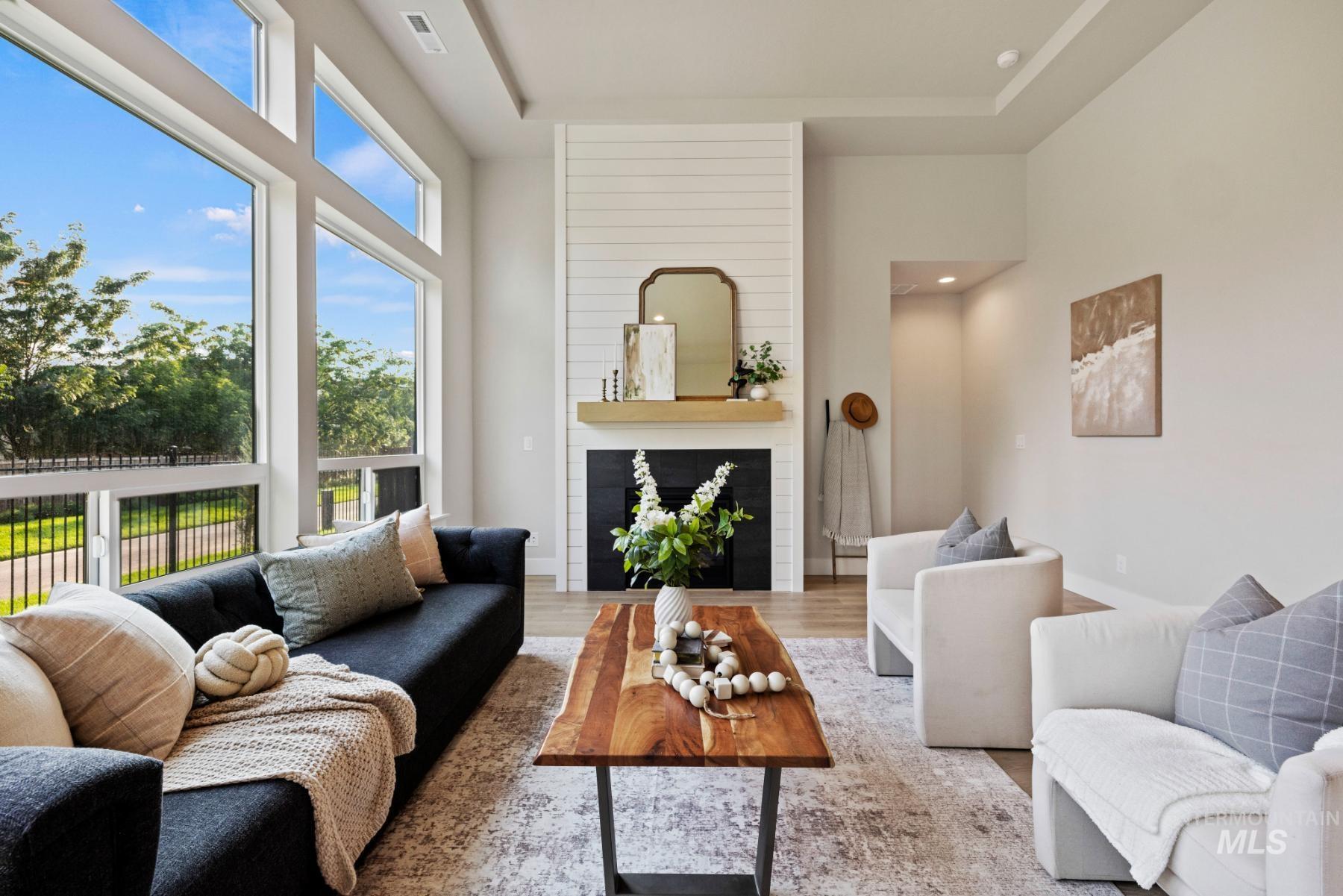 Living room featuring a fireplace, wood finished floors, and a raised ceiling