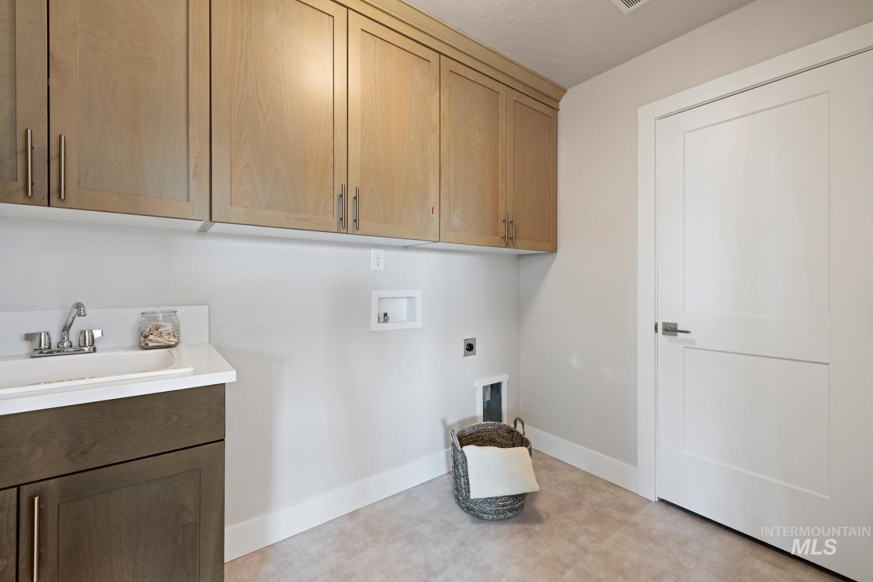 Washroom featuring washer hookup, electric dryer hookup, and cabinet space