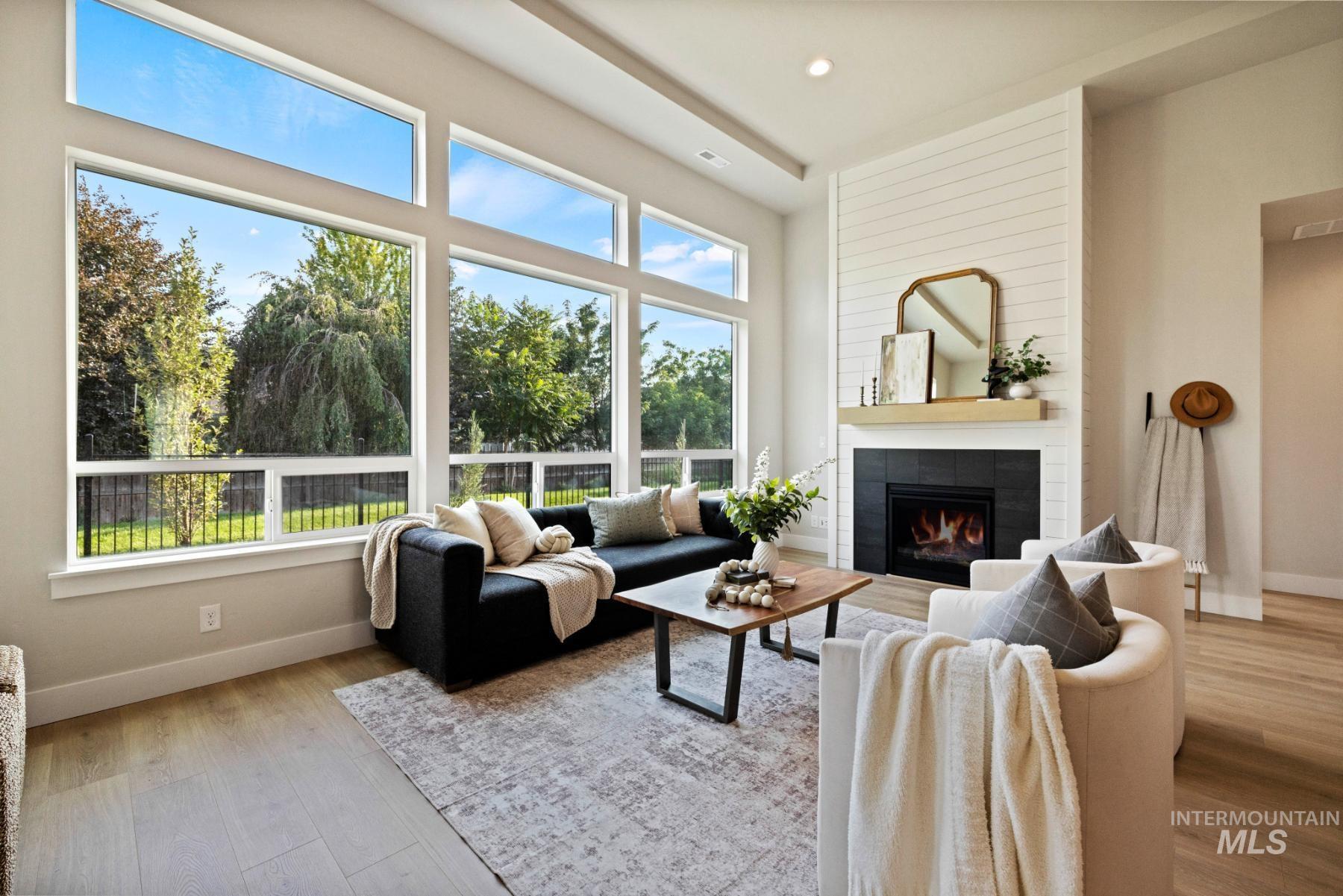 Living room with a tiled fireplace, light wood-style floors, and recessed lighting