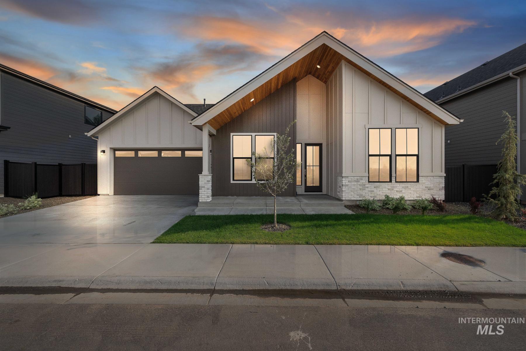 View of front of house with board and batten siding, driveway, and an attached garage