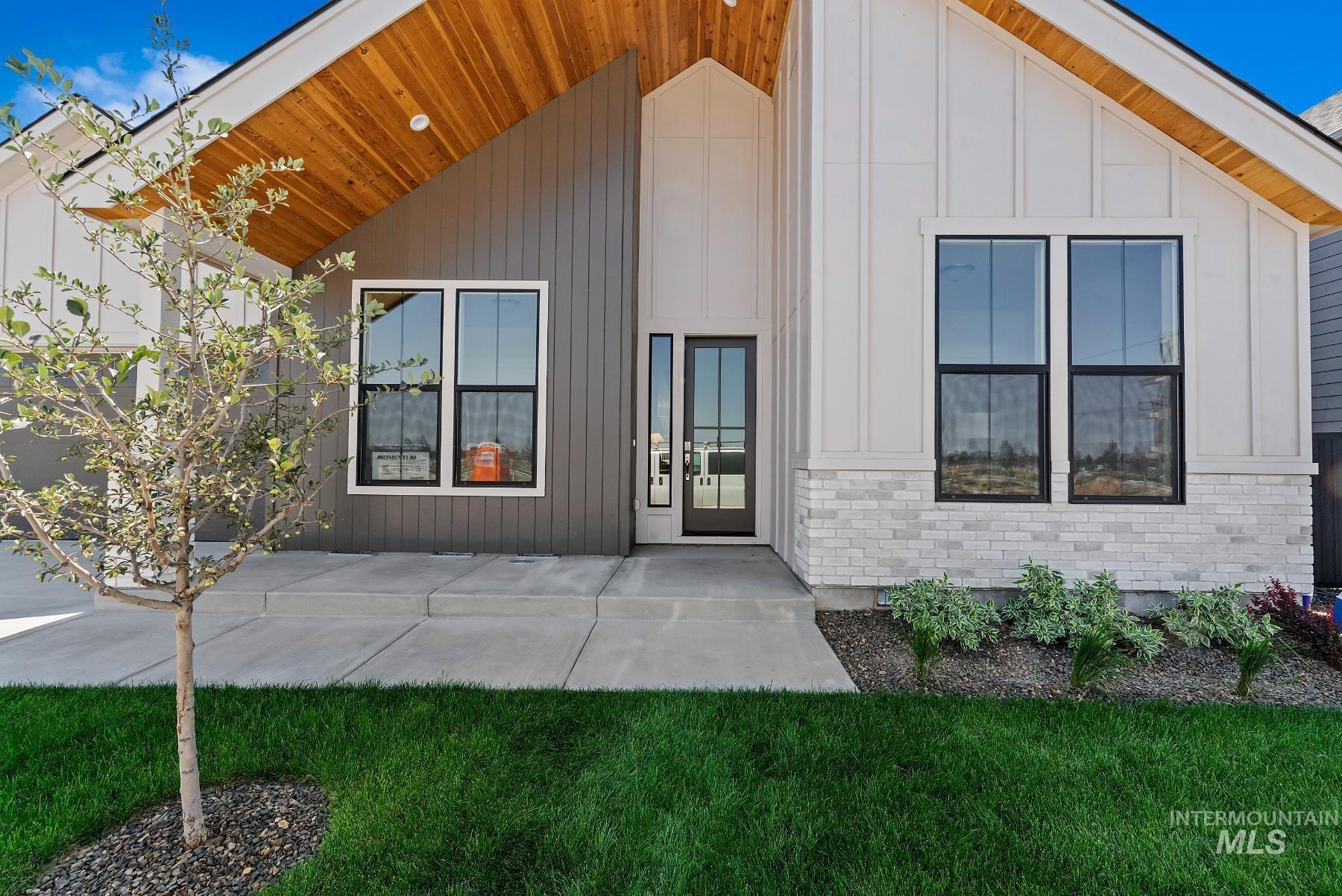 View of front of property with board and batten siding, a porch, and a front yard