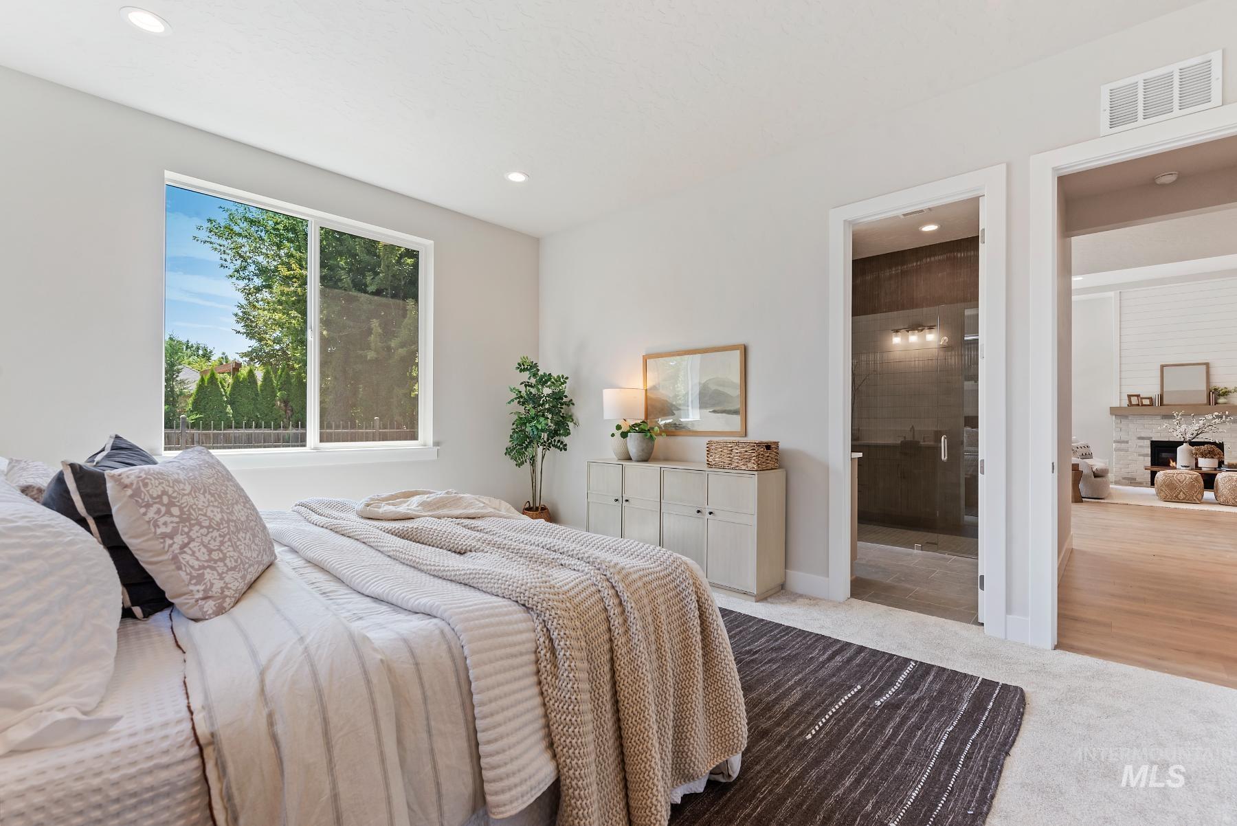 Bedroom featuring carpet, recessed lighting, and a fireplace