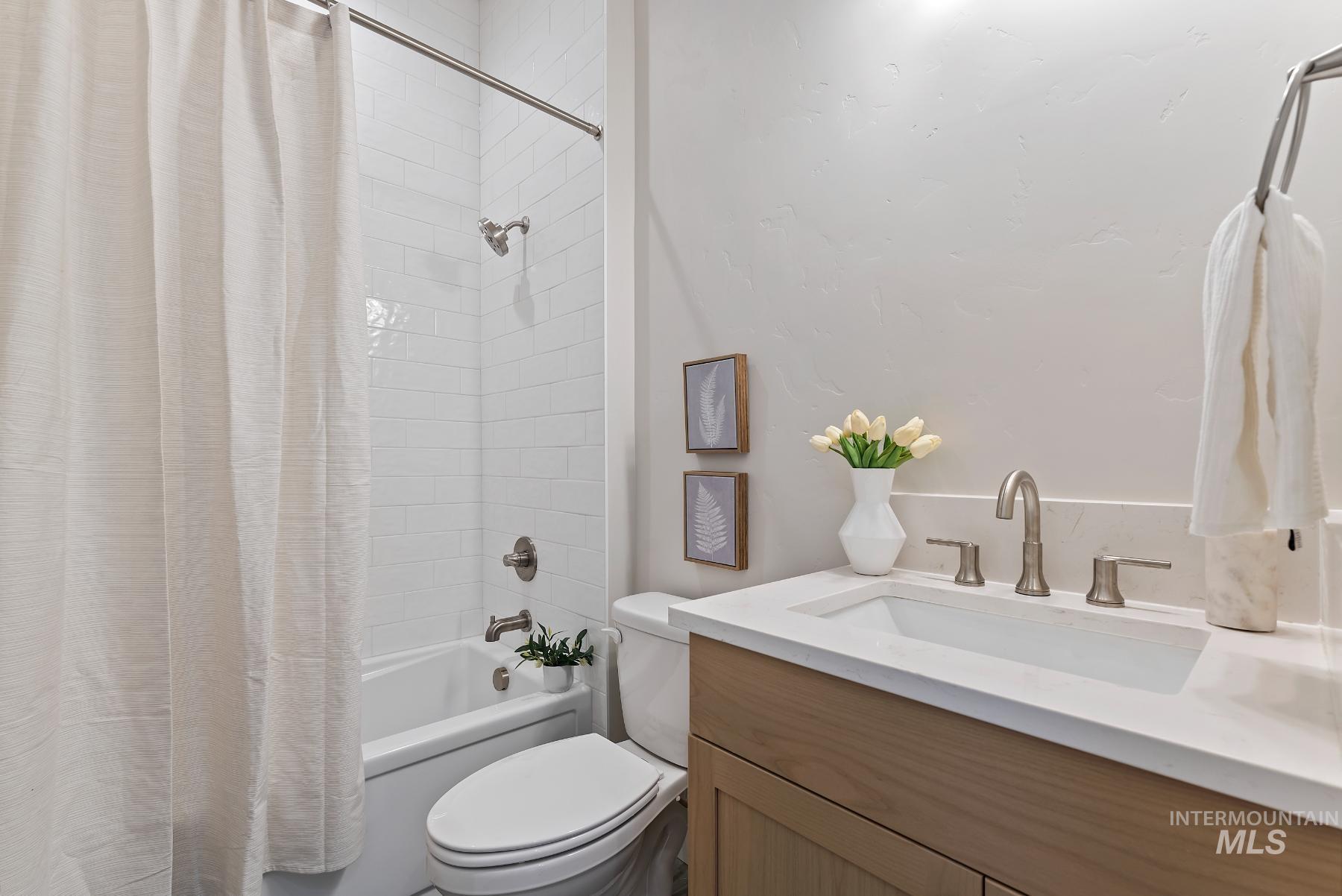 Bathroom featuring shower / bath combo with shower curtain and vanity