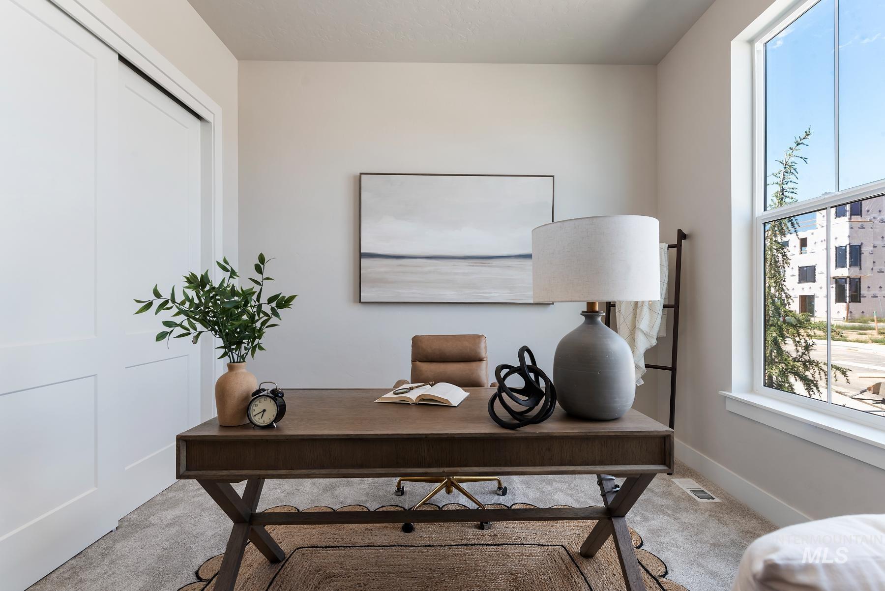 Carpeted home office with plenty of natural light