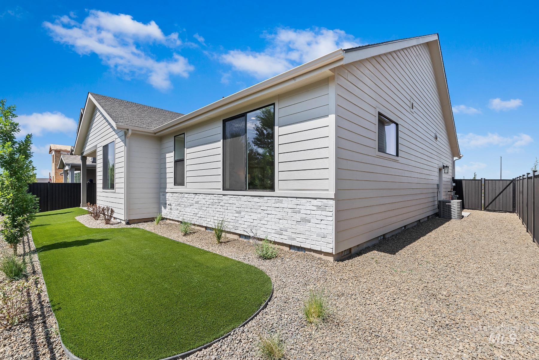 View of side of property with a fenced backyard, a shingled roof, and crawl space