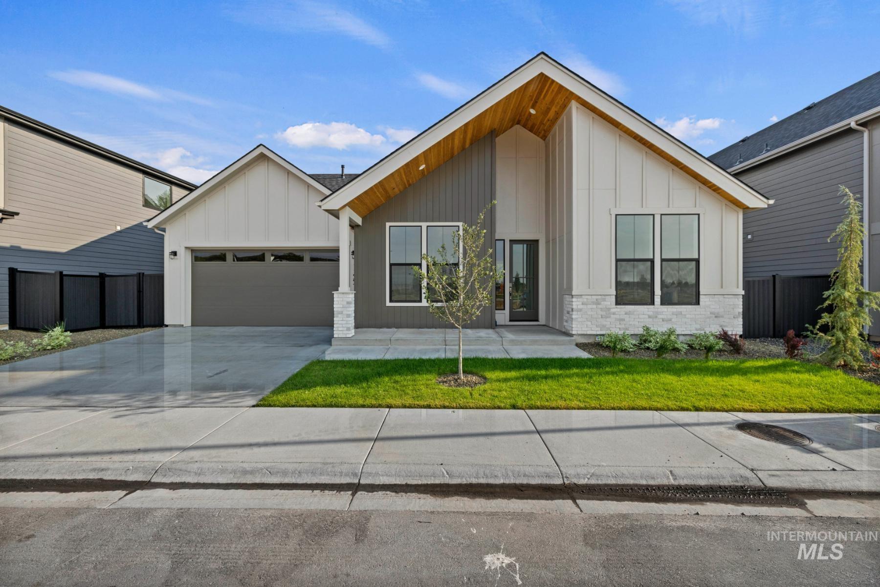 View of front of property with board and batten siding, driveway, a garage, and covered porch