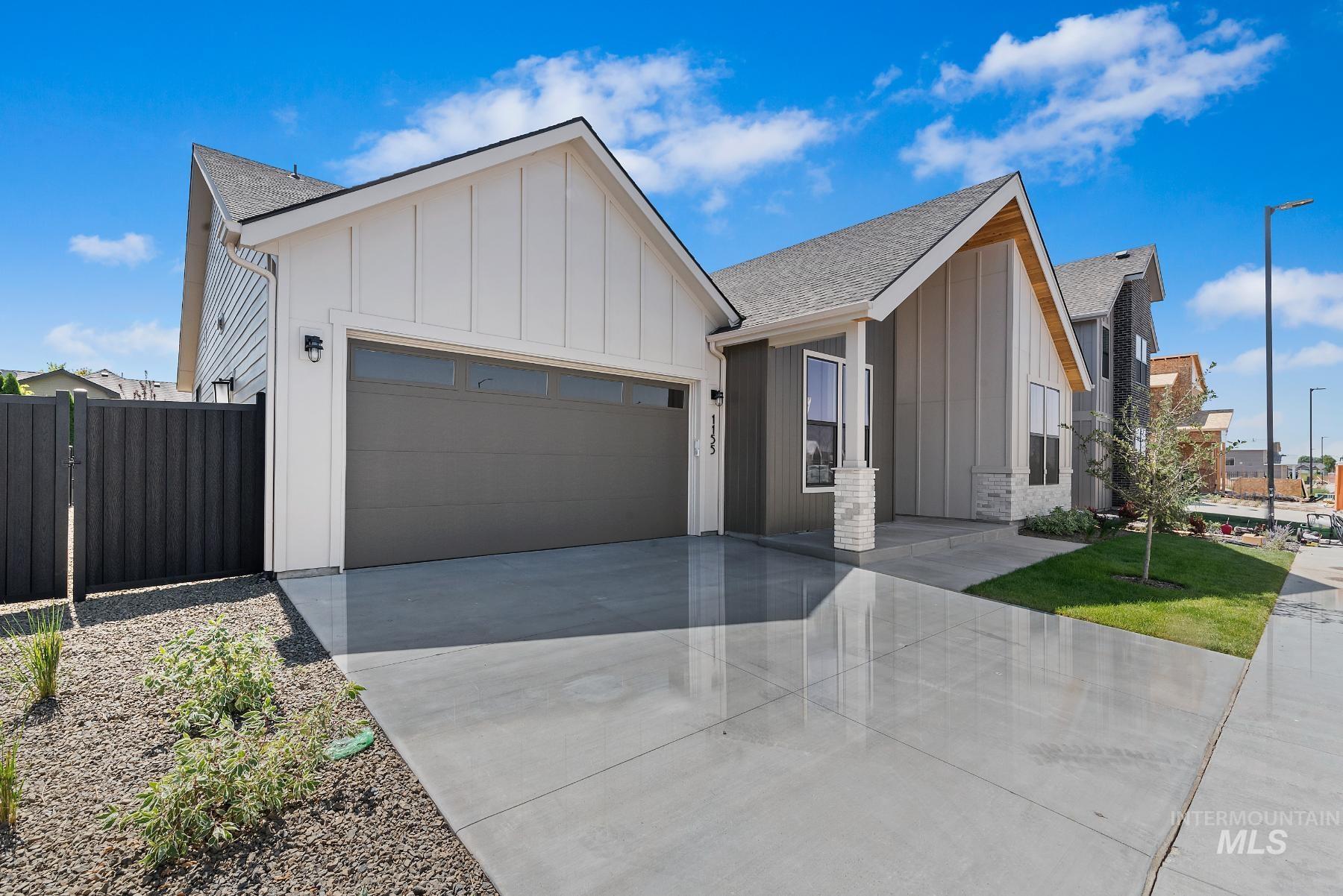 Modern inspired farmhouse featuring board and batten siding, roof with shingles, concrete driveway, and an attached garage