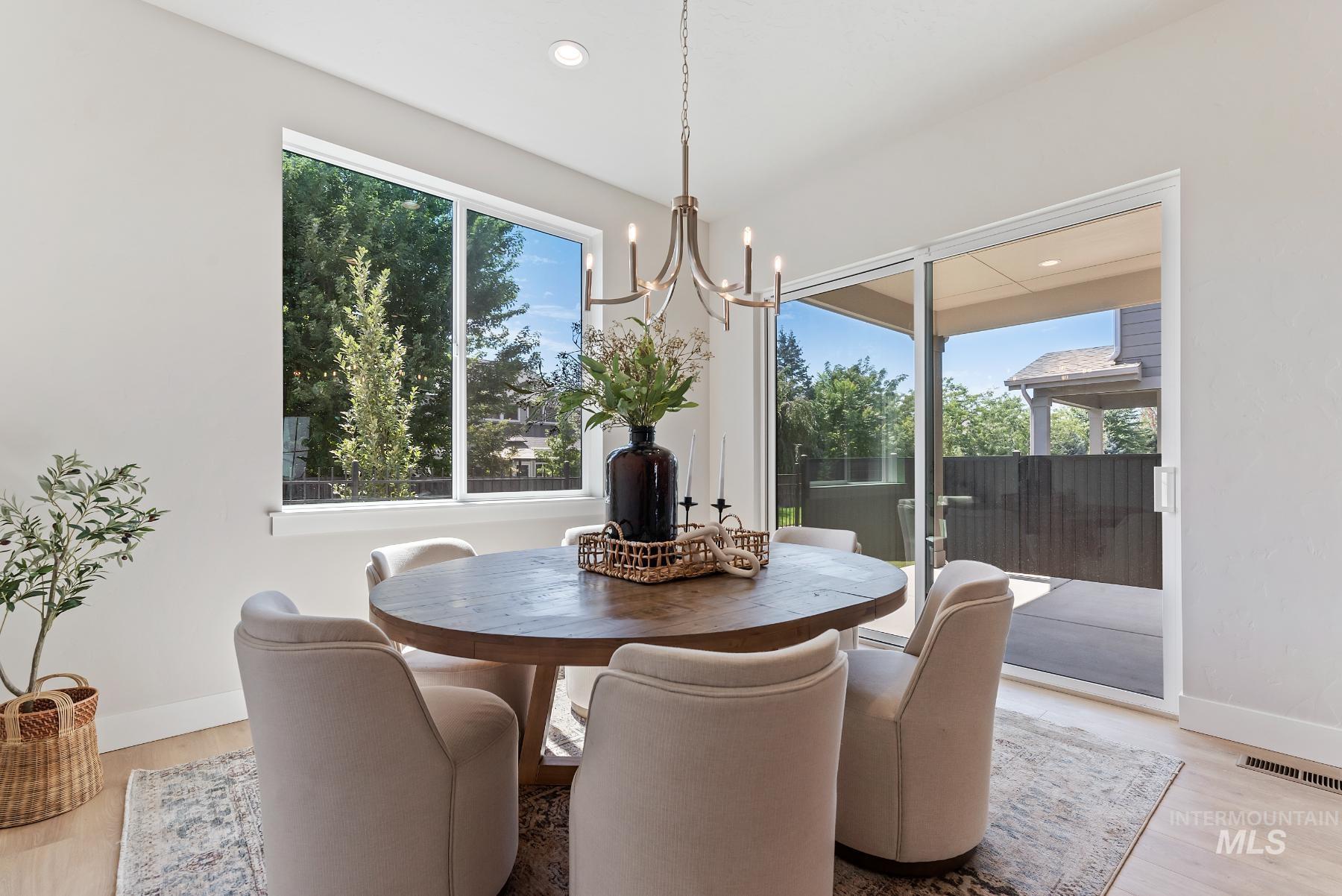 Dining room featuring light wood-style flooring, a chandelier, and recessed lighting