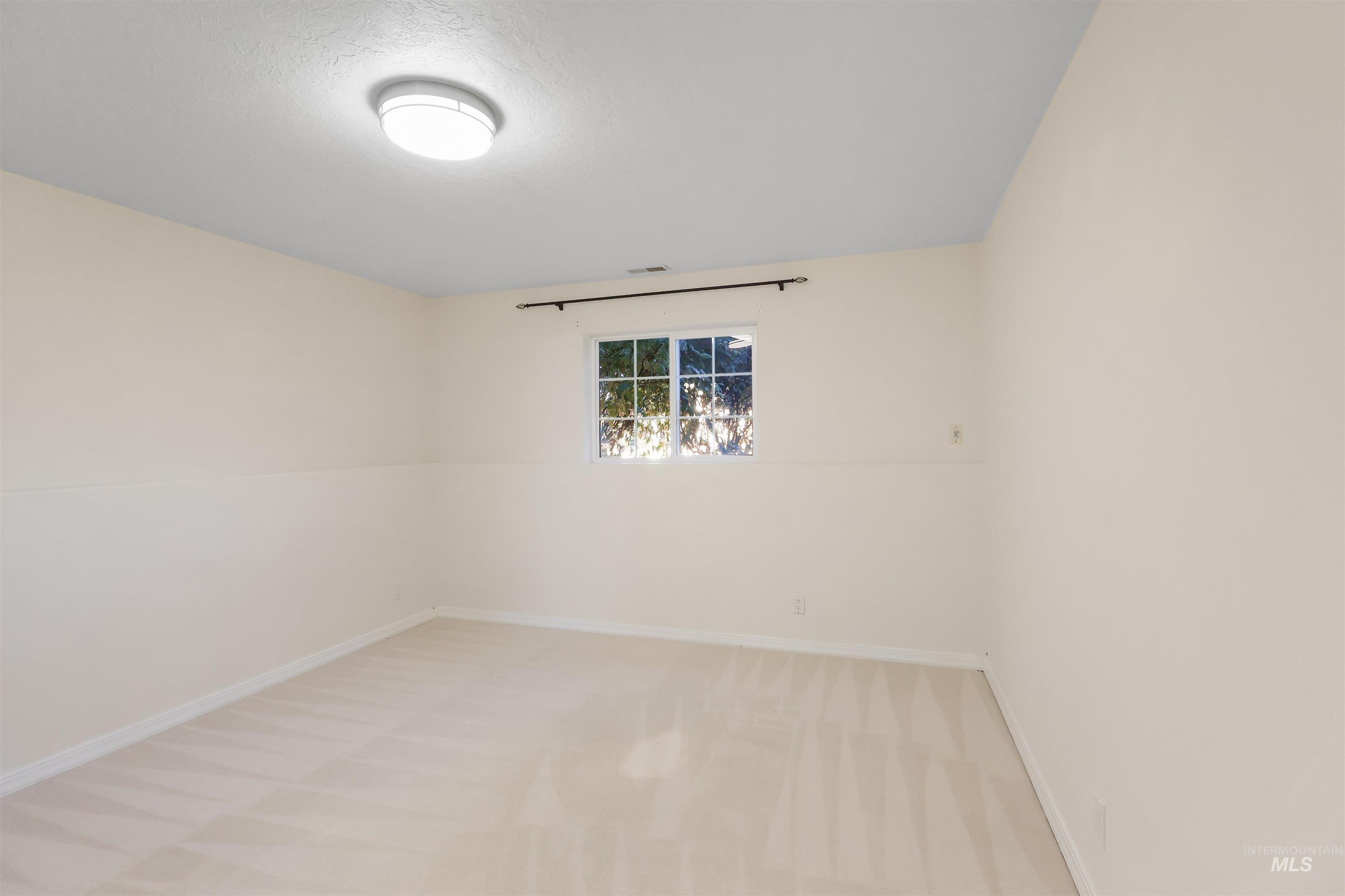 Unfurnished room with light carpet and baseboards