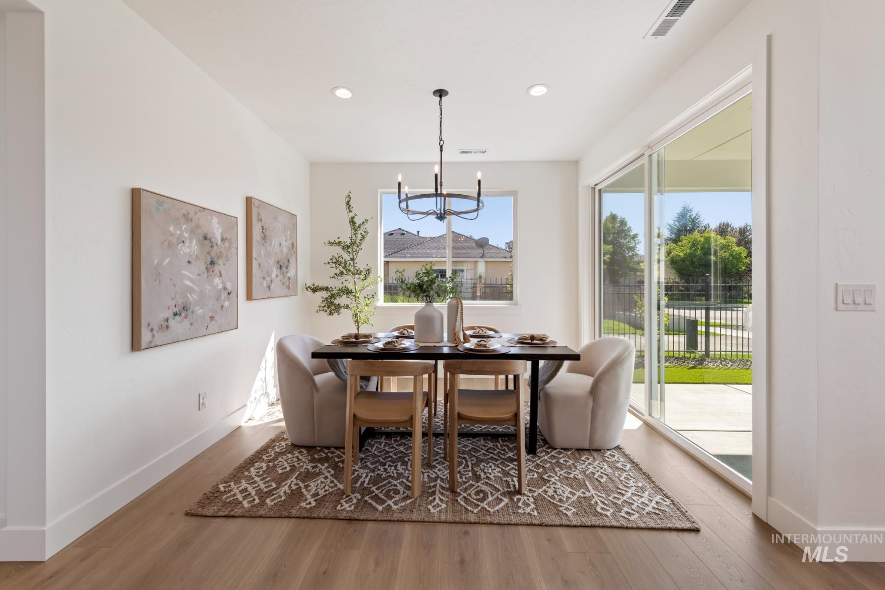 Dining area with a chandelier, light wood-style flooring, and recessed lighting