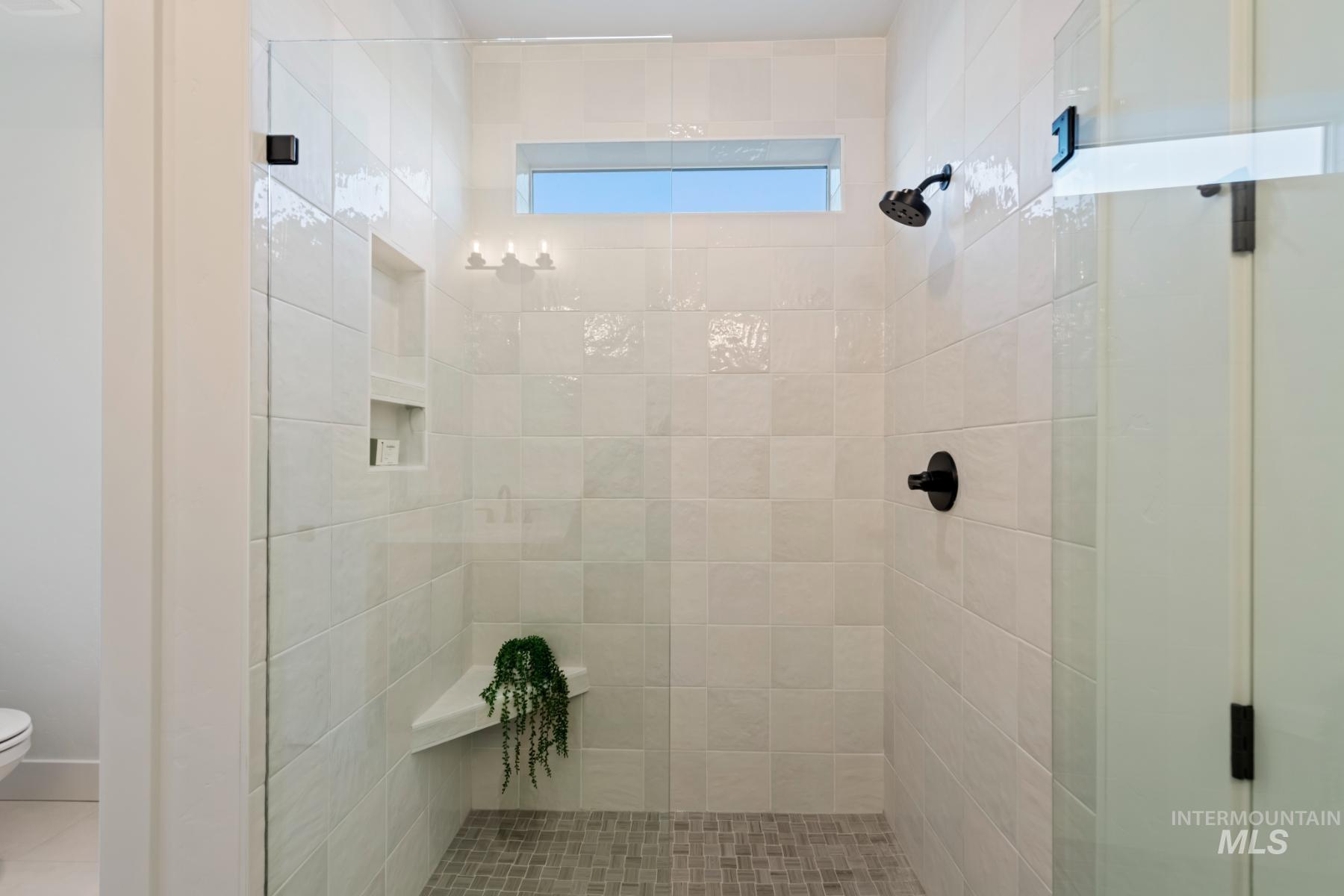 Bathroom featuring a stall shower and toilet