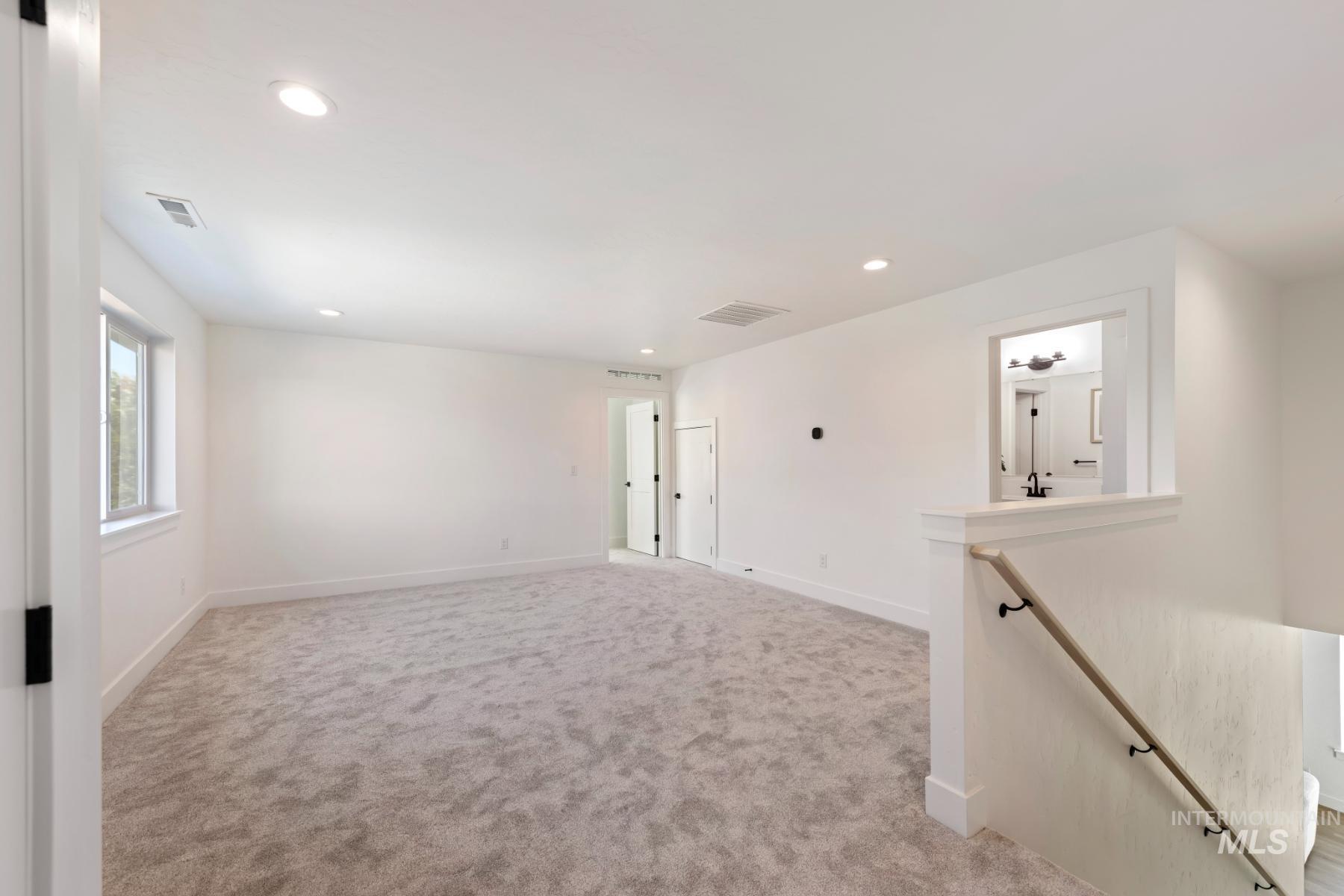 Empty room featuring recessed lighting and light carpet