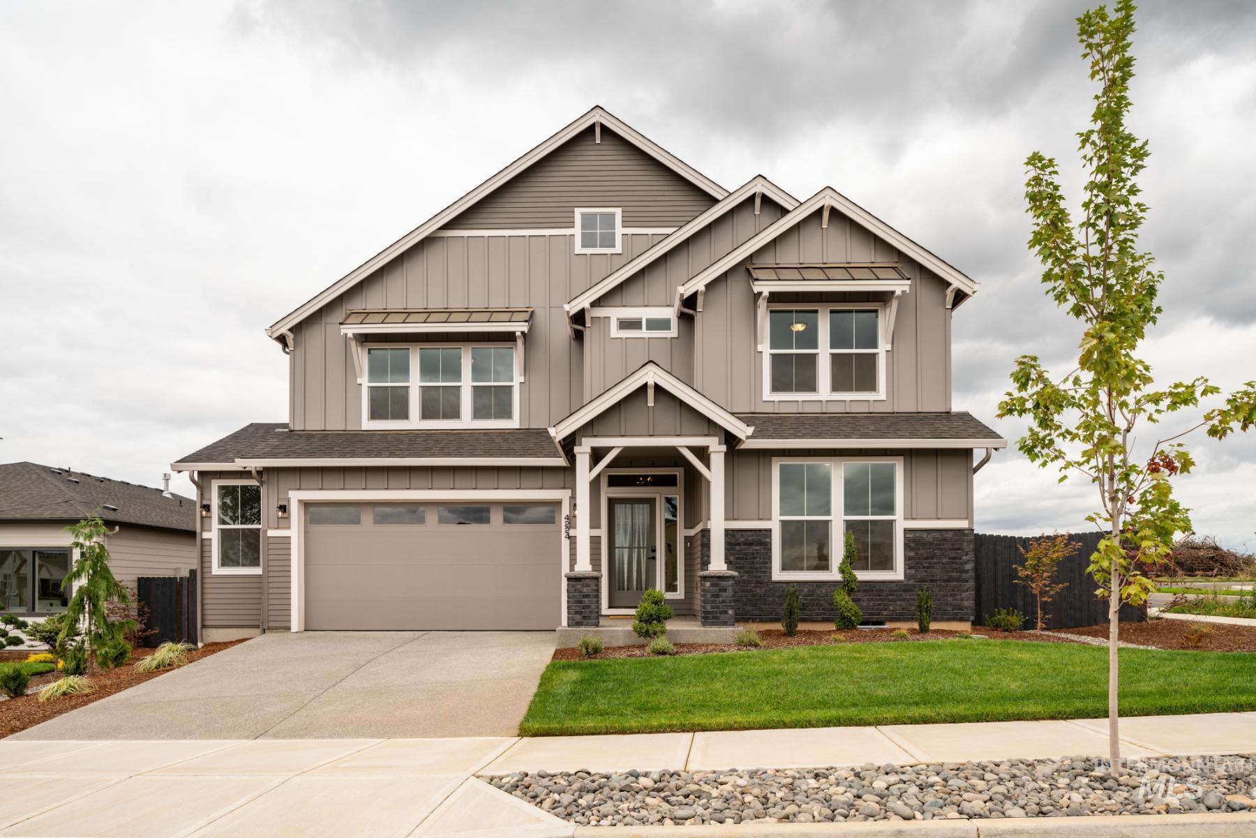 Craftsman inspired home with board and batten siding, a garage, concrete driveway, stone siding, and a shingled roof