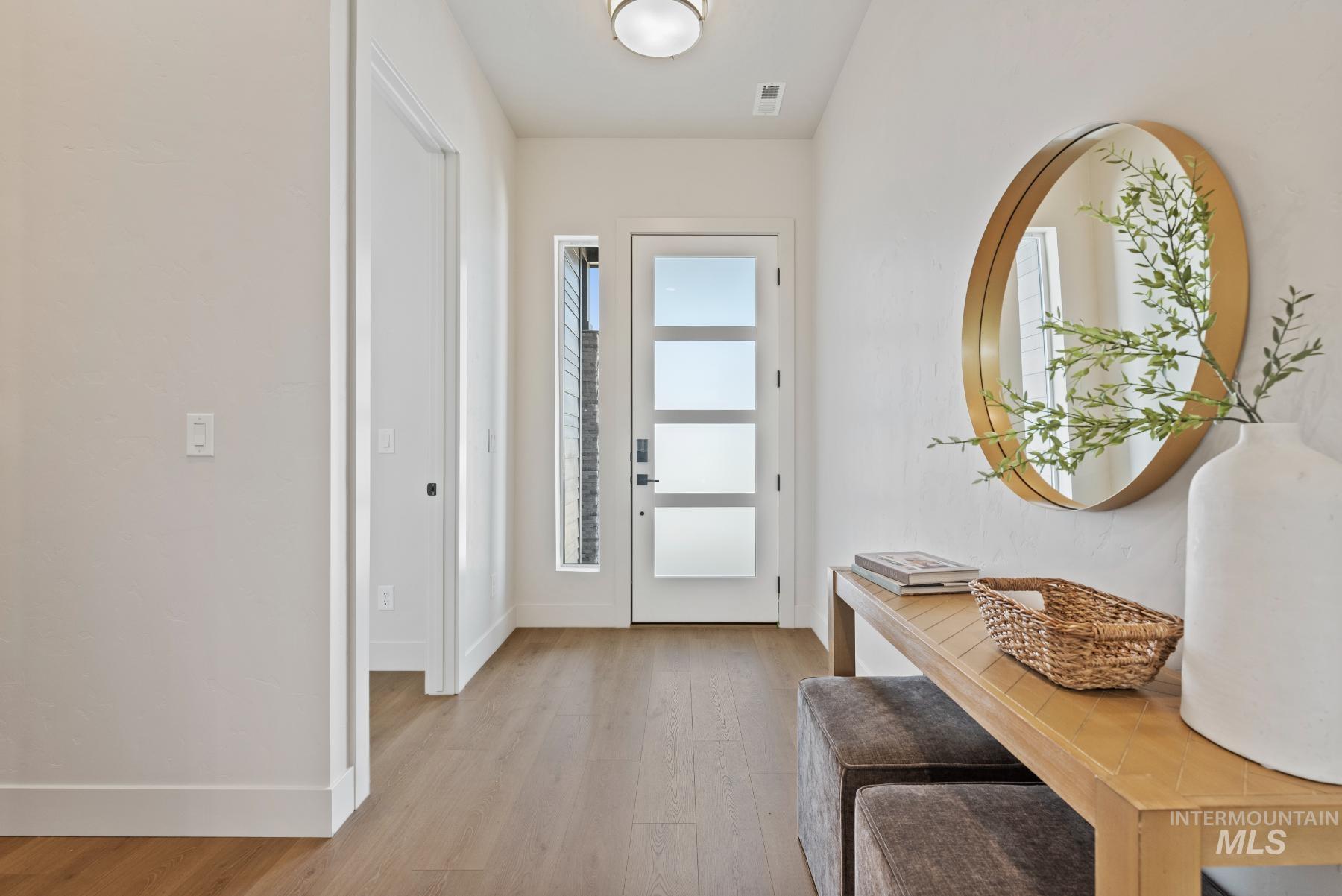 Entrance foyer with baseboards and light wood-style flooring