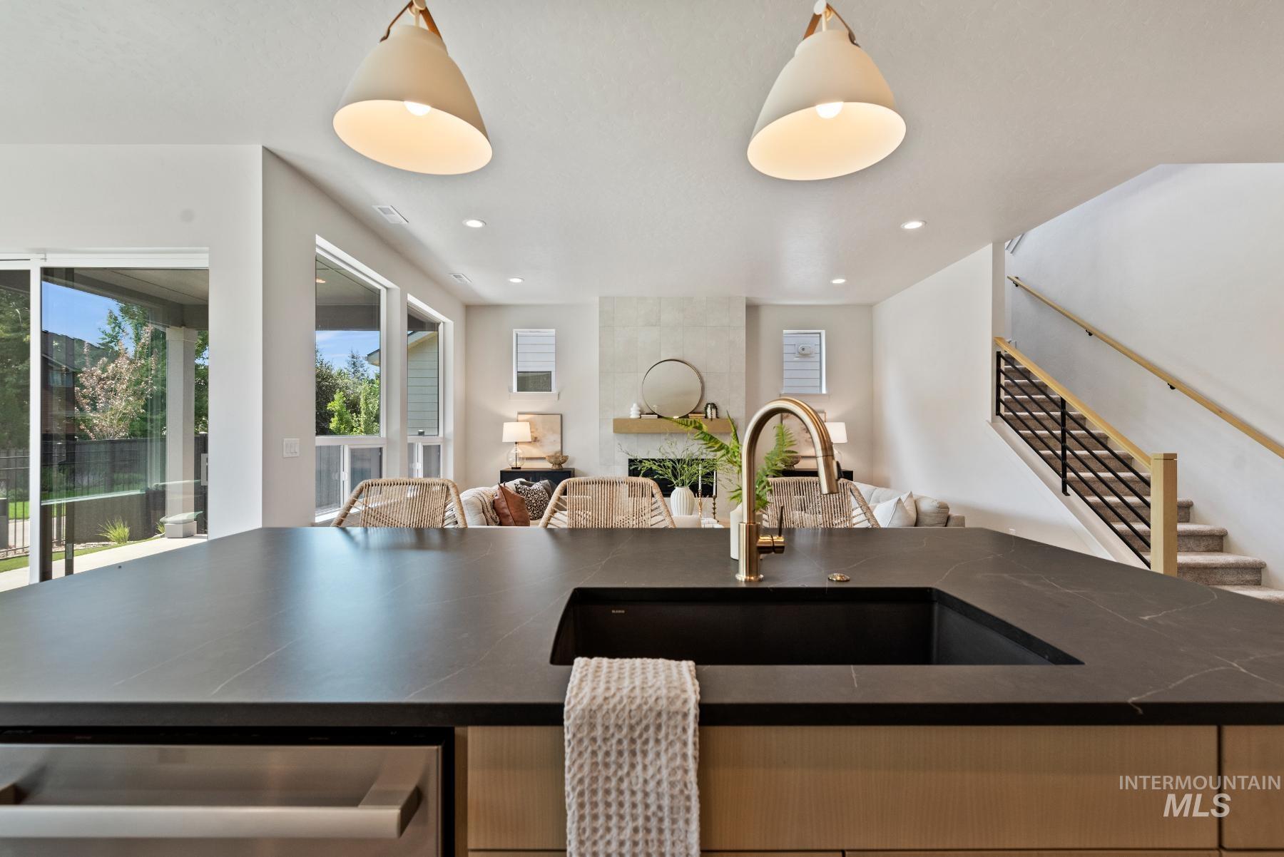 Kitchen featuring decorative light fixtures, an island with sink, dark stone counters, and recessed lighting