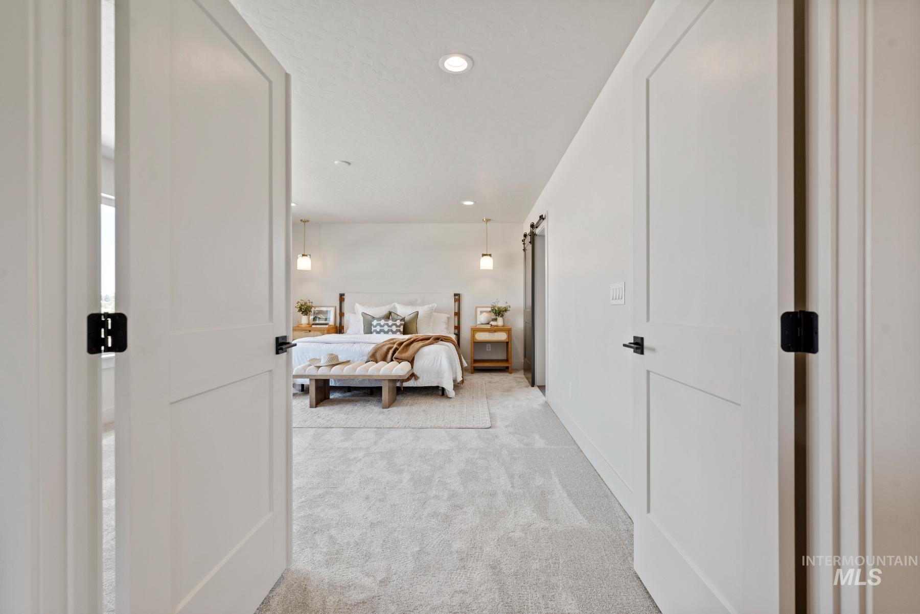 Bedroom with carpet, recessed lighting, and a barn door