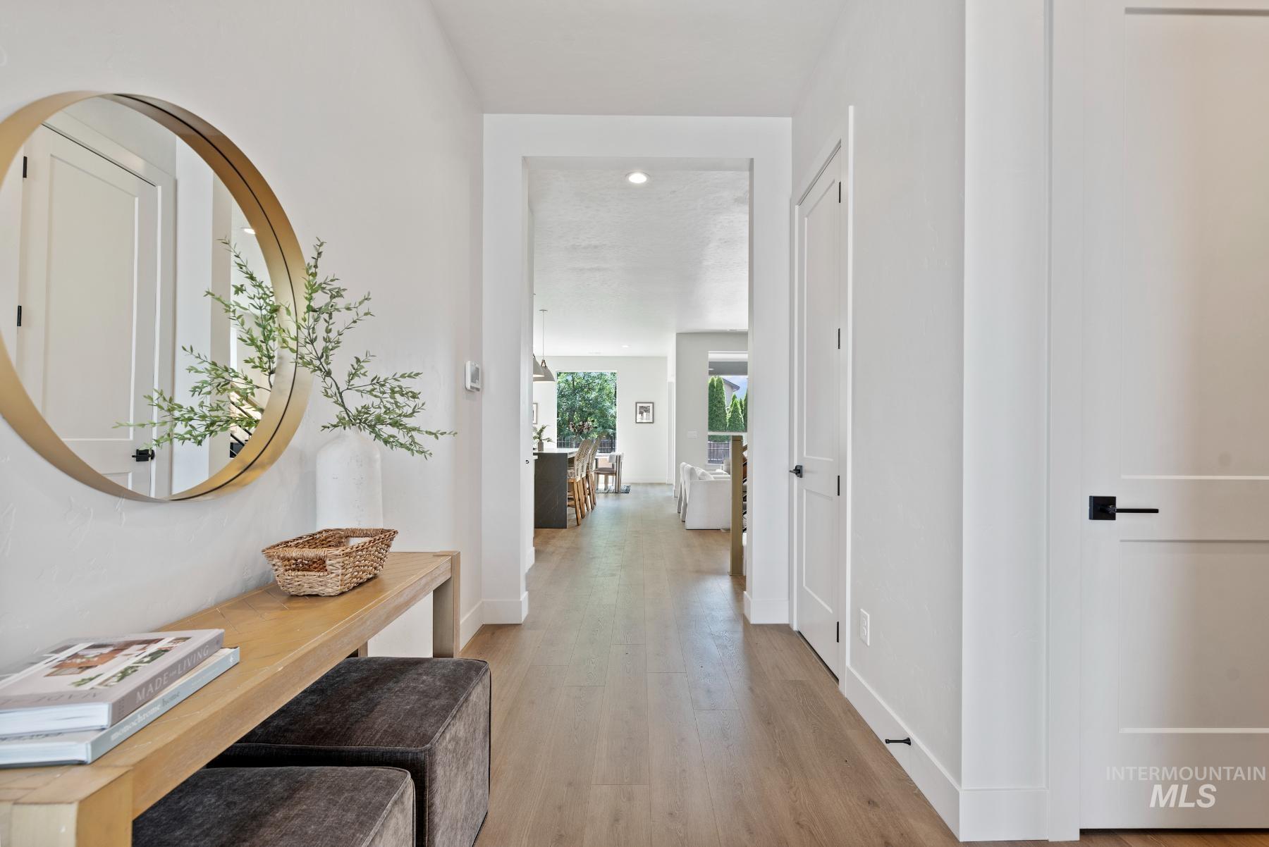 Corridor with light wood-style flooring and baseboards