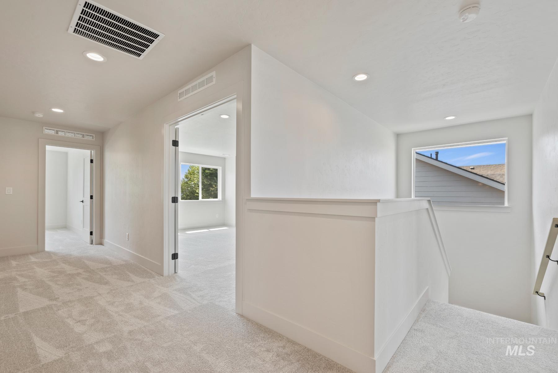 Corridor featuring an upstairs landing, light colored carpet, and recessed lighting