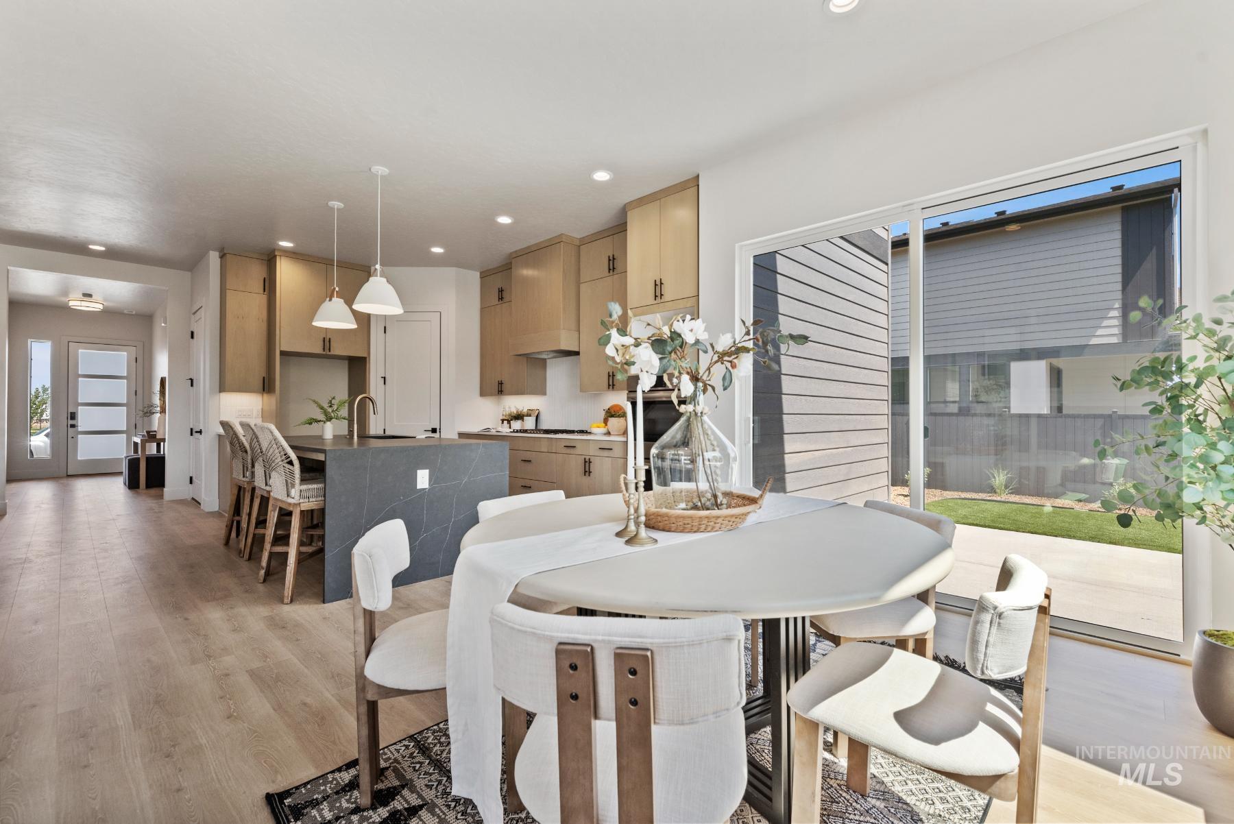 Dining room with light wood-type flooring and recessed lighting