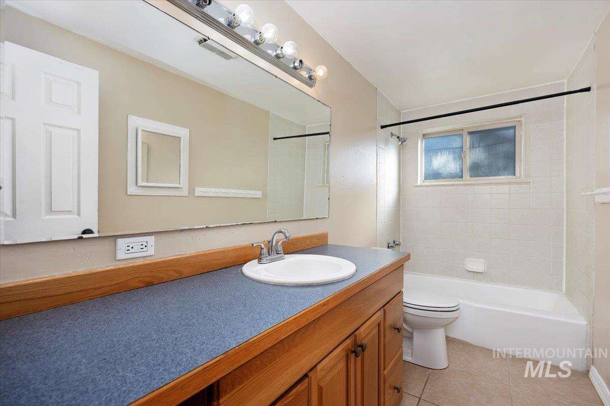 Full bathroom featuring vanity, tub / shower combination, and light tile patterned floors