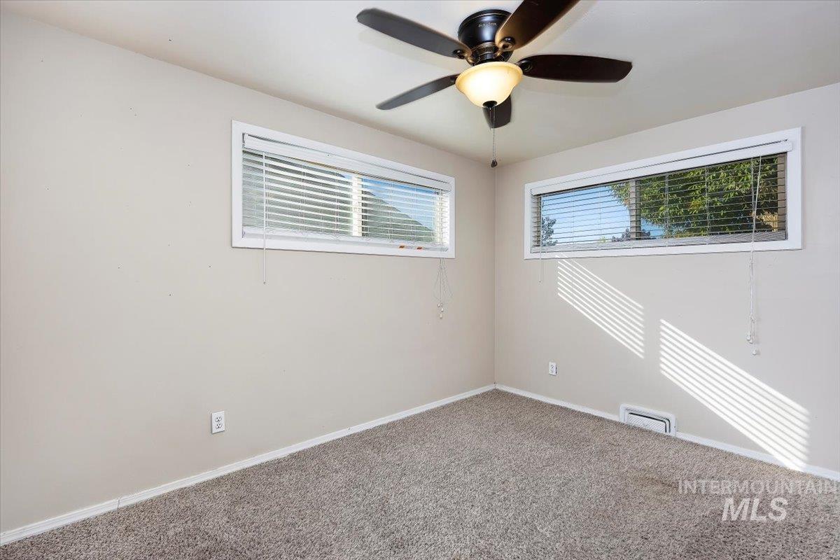 Spare room featuring carpet and a ceiling fan