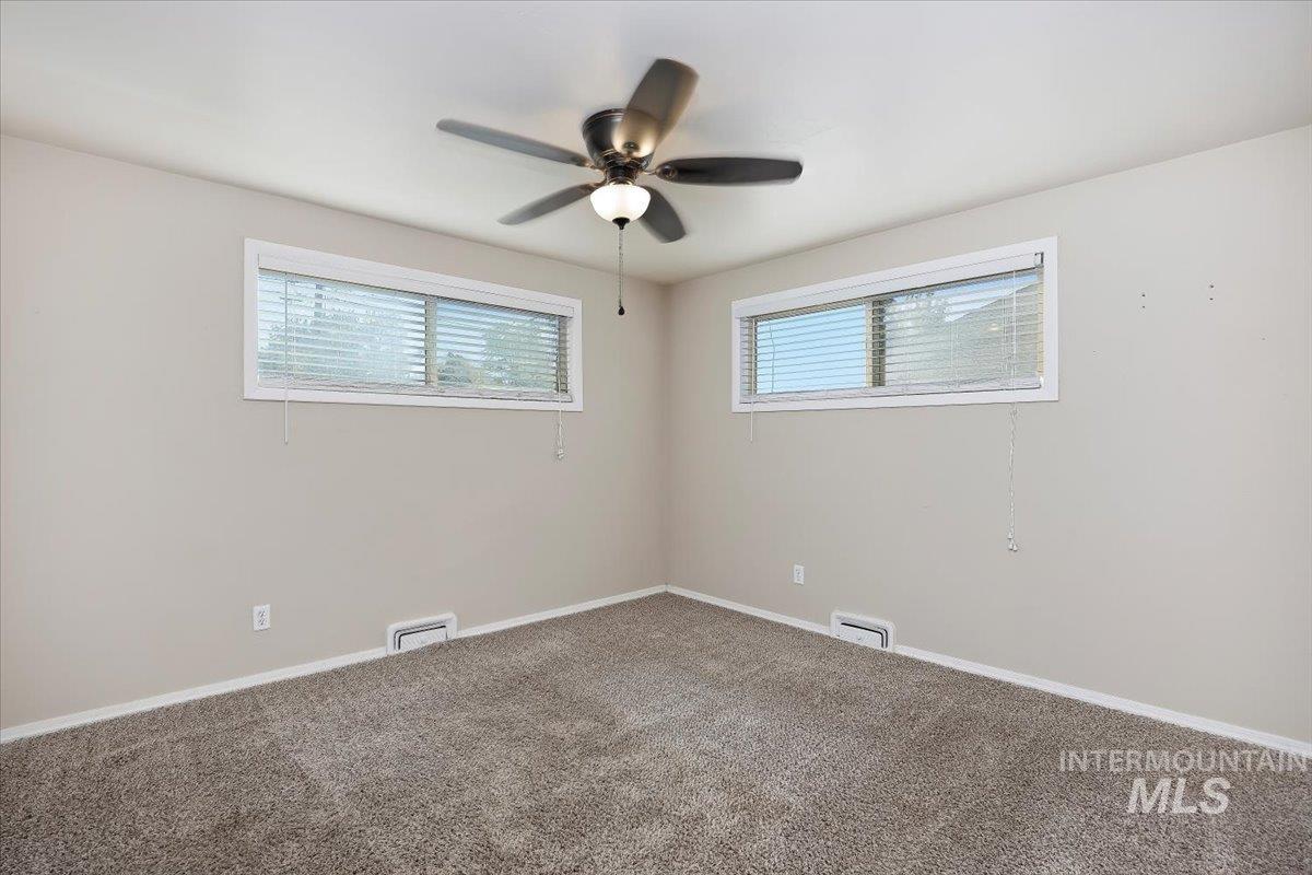 Spare room with carpet floors, healthy amount of natural light, and ceiling fan