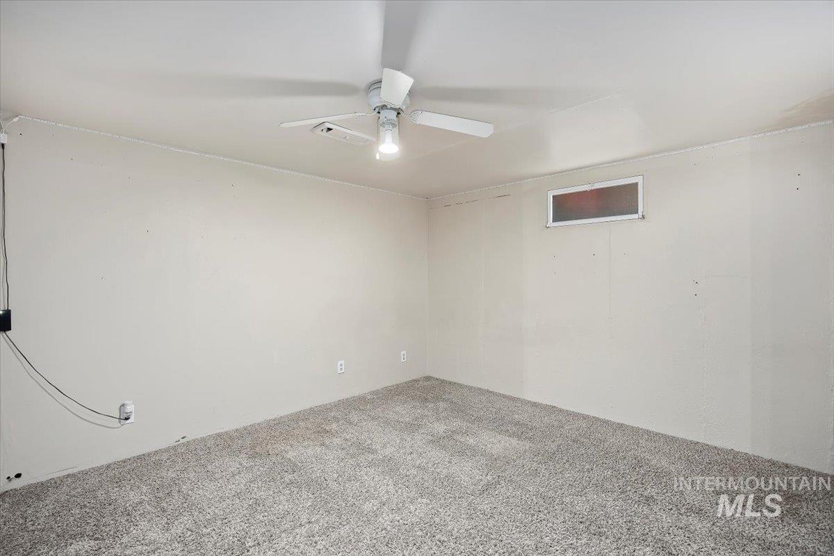 Empty room with carpet floors and ceiling fan