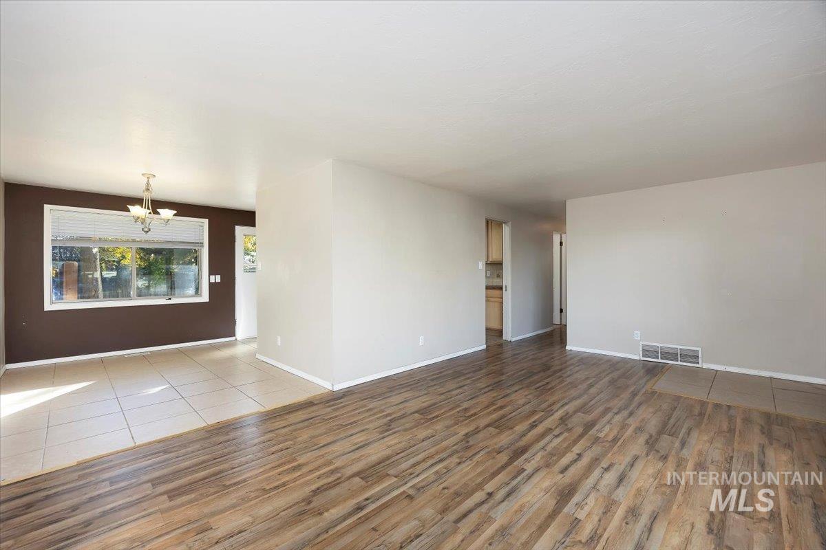 Empty room featuring a chandelier and wood finished floors