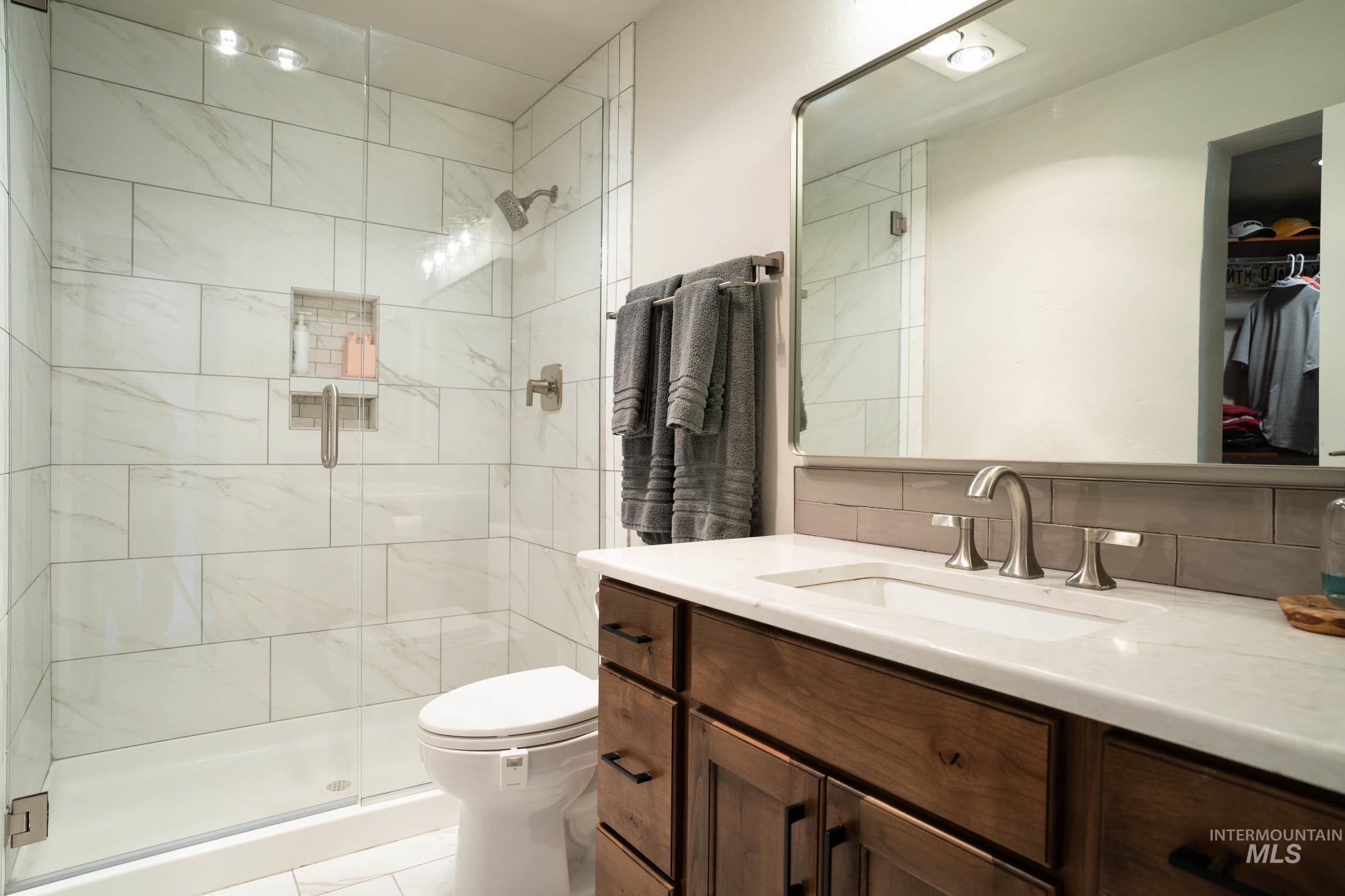 with custom tile walk-in shower and quartz countertop