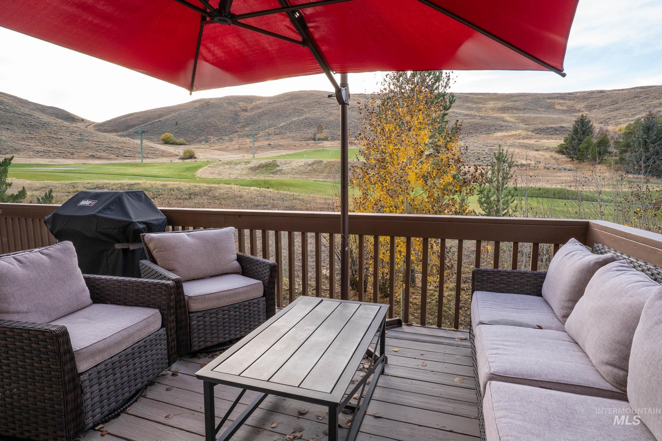 Wooden deck with an outdoor living space, area for grilling, and a mountain view
