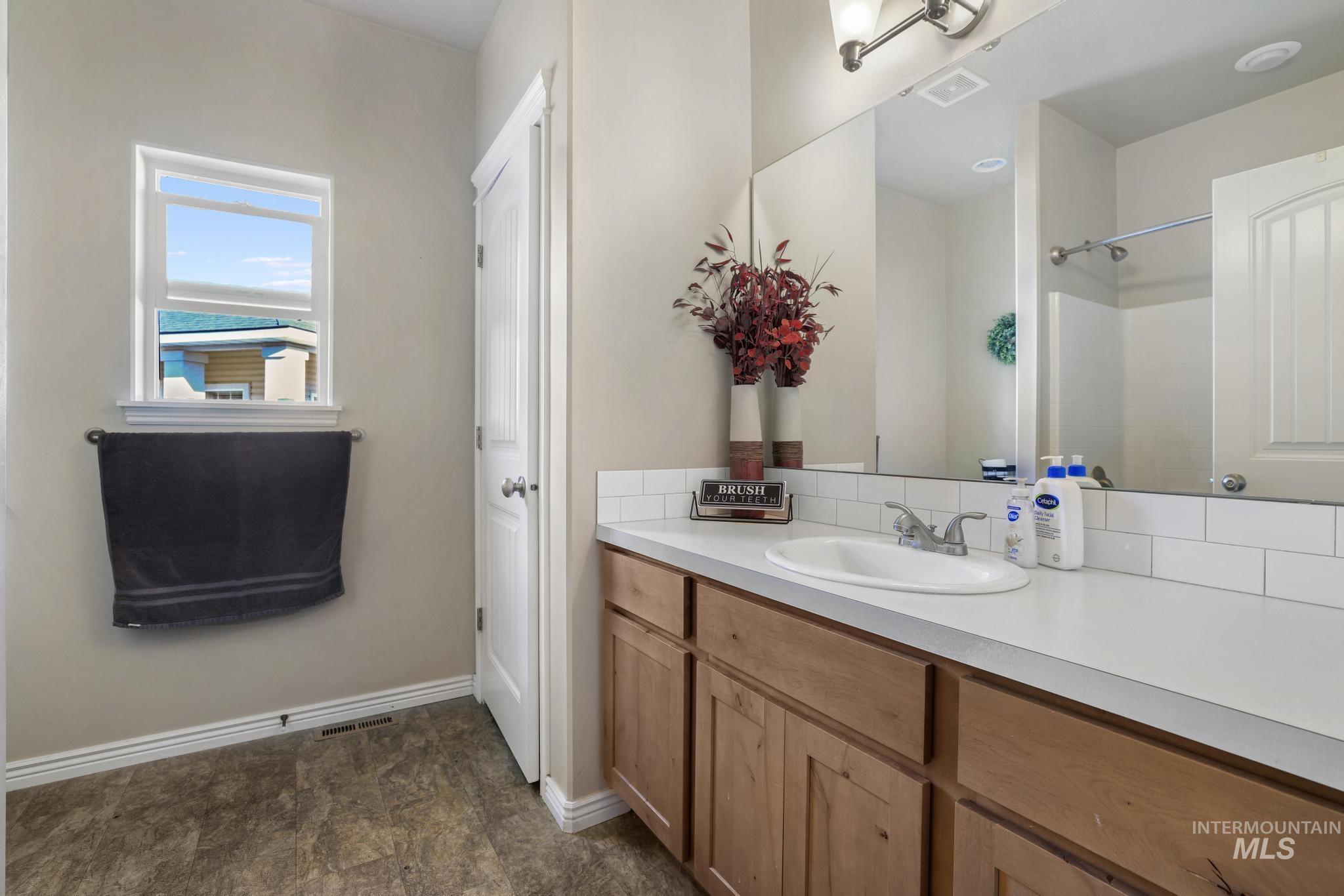 Bathroom featuring vanity and a shower