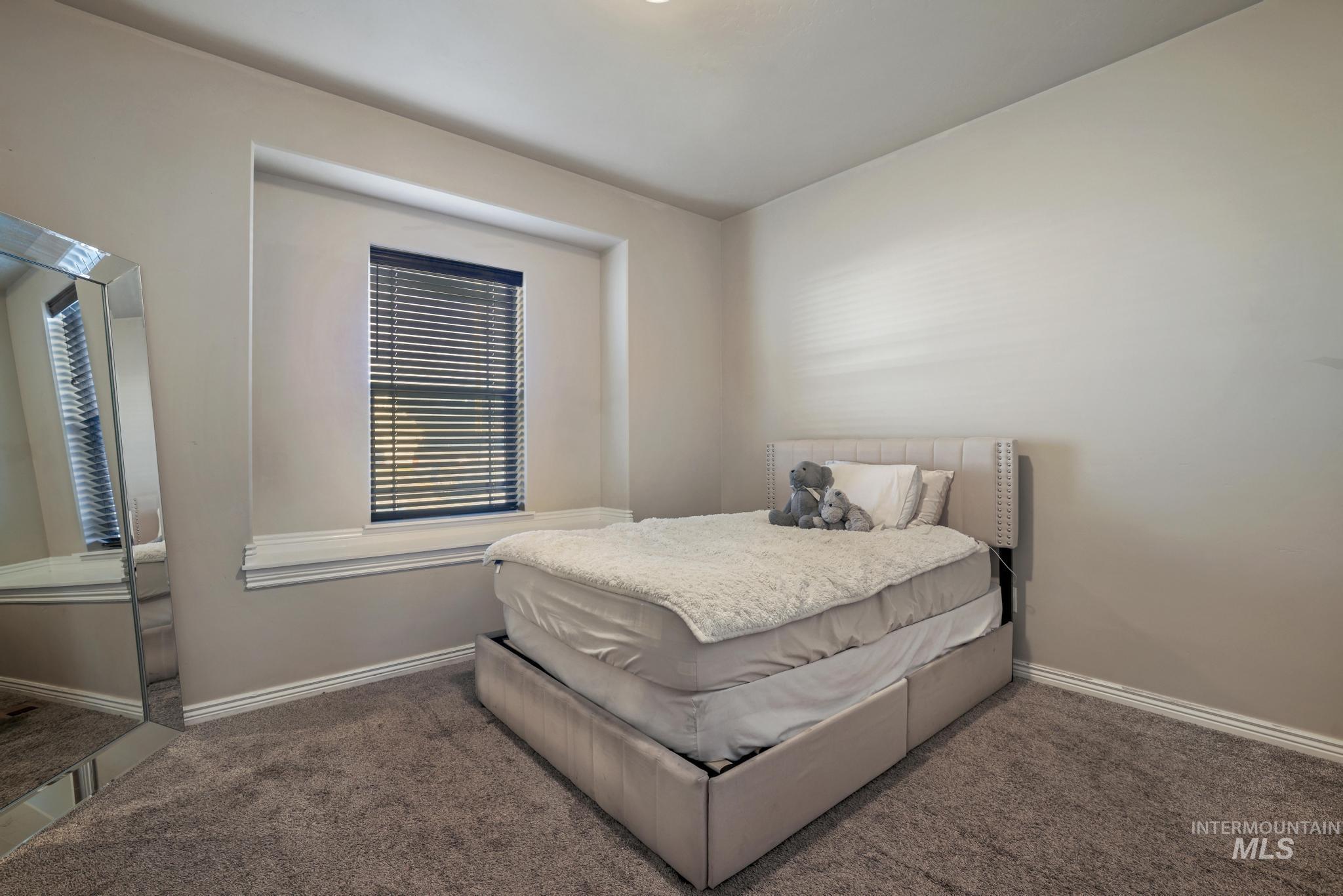 Bedroom featuring carpet flooring and multiple windows