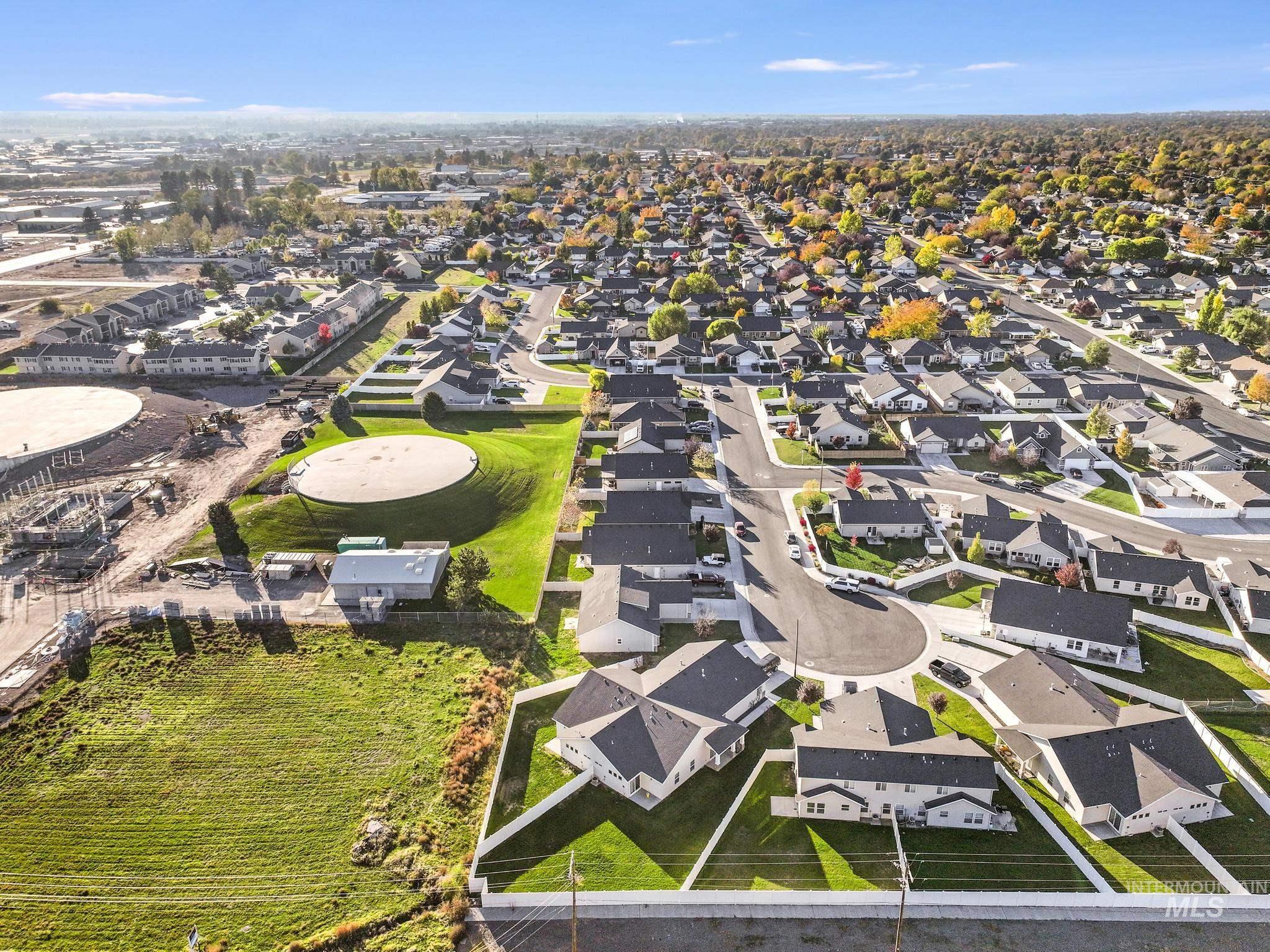 Aerial view of property and surrounding area featuring nearby suburban area