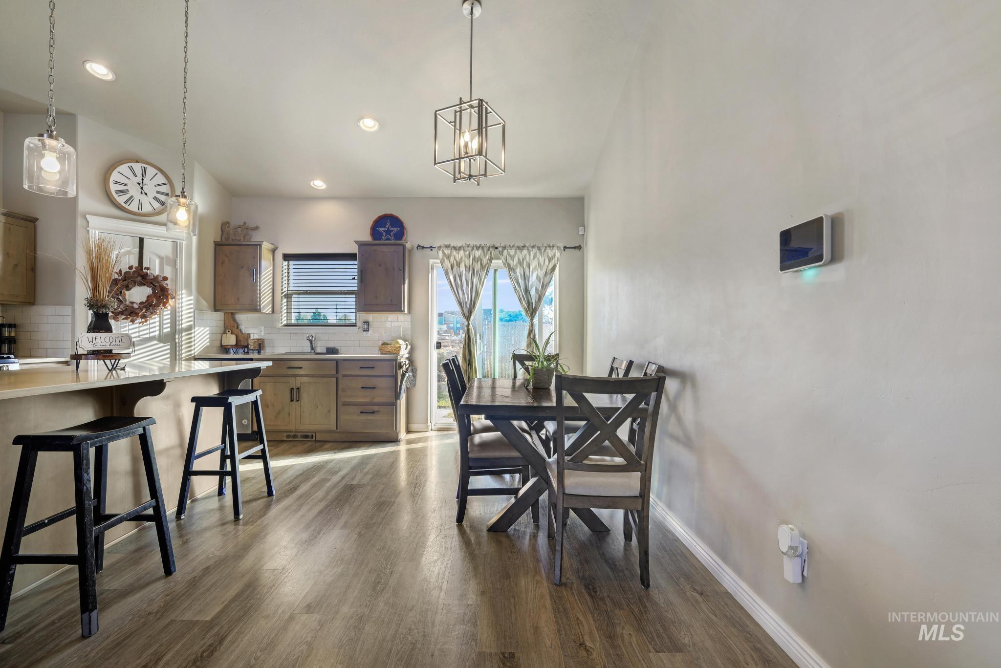 Dining area featuring dark wood finished floors and recessed lighting