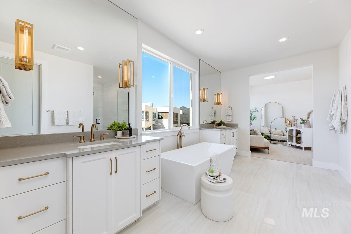 Bathroom featuring vanity, recessed lighting, a freestanding tub, and a shower stall