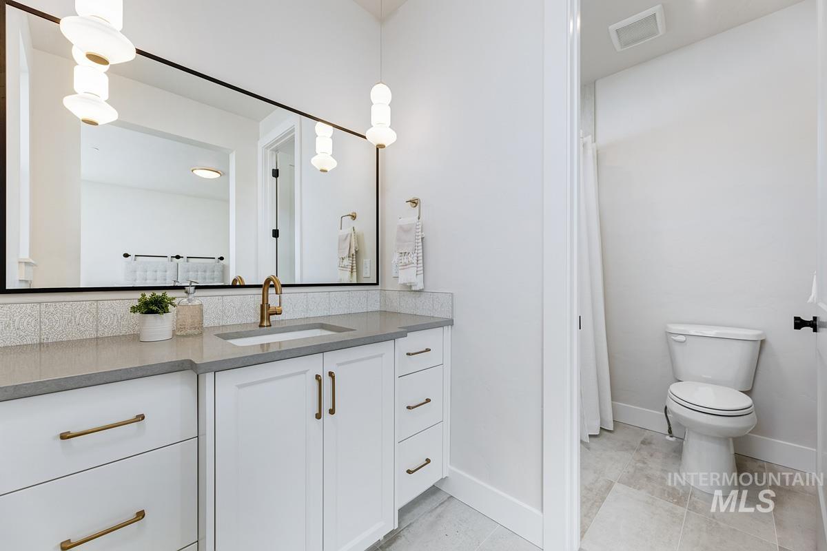 Bathroom featuring vanity, light tile patterned floors, and a shower with curtain