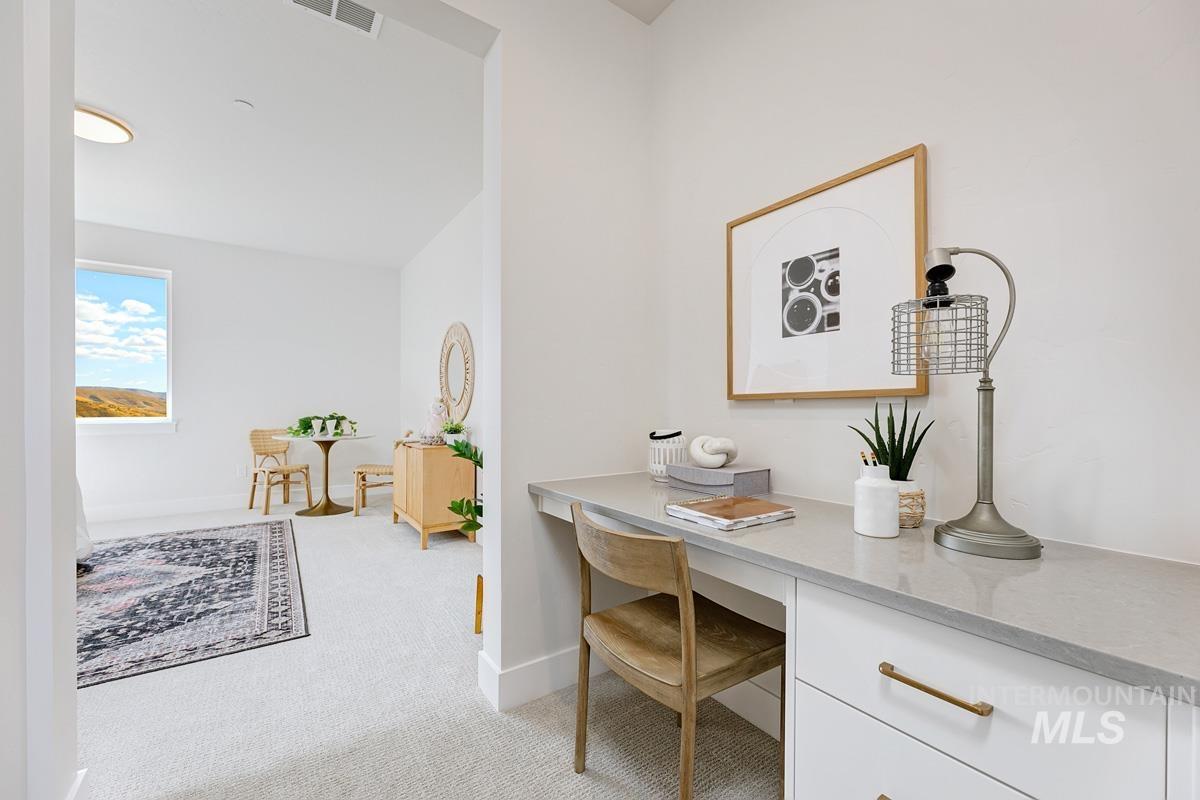 Office area featuring light colored carpet and built in study area
