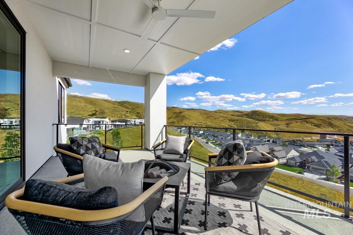 Balcony featuring ceiling fan, an outdoor hangout area, a mountain view, a sunroom, and a residential view