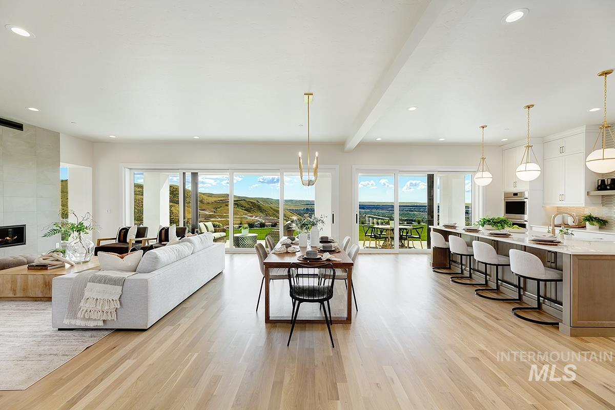 Living area featuring recessed lighting, light wood-type flooring, a chandelier, beam ceiling, and a large fireplace