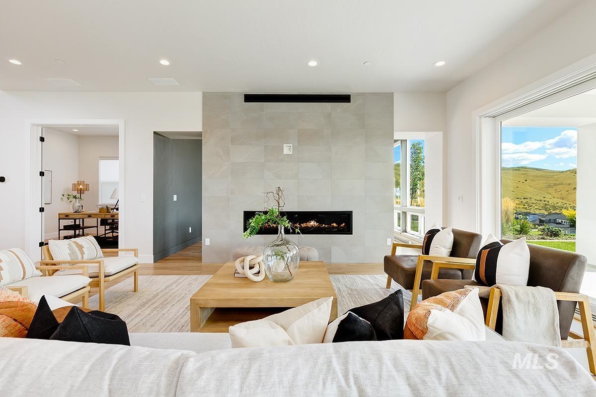 Living area with a tile fireplace, recessed lighting, and wood finished floors