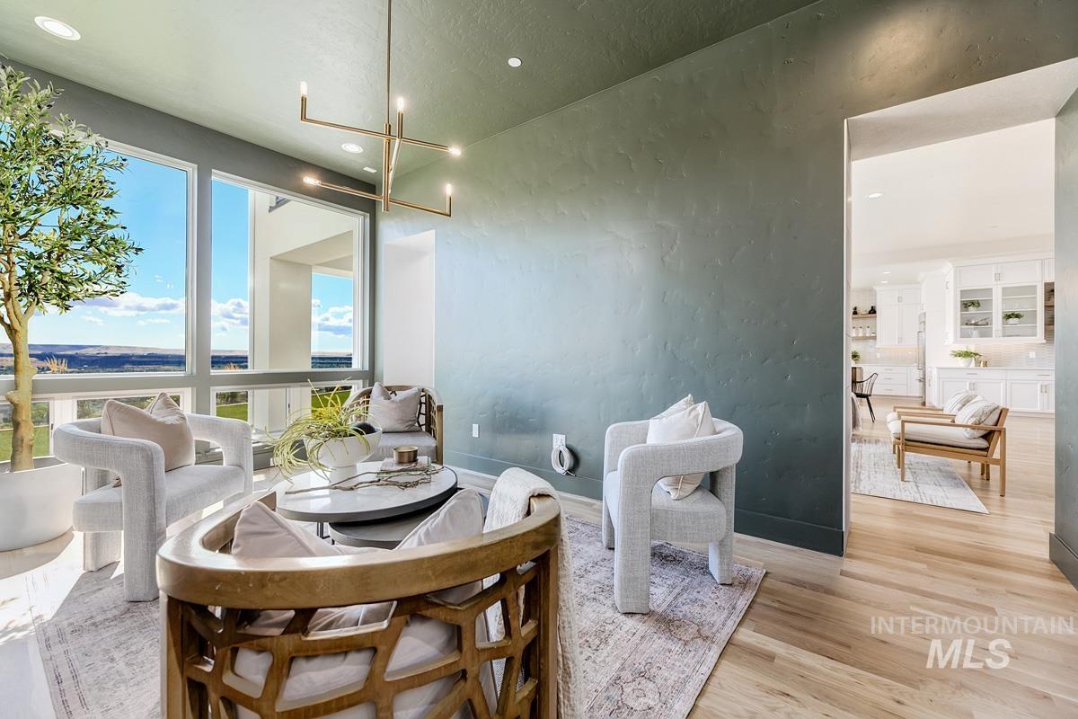 Dining space featuring light wood finished floors, a textured wall, a chandelier, and recessed lighting