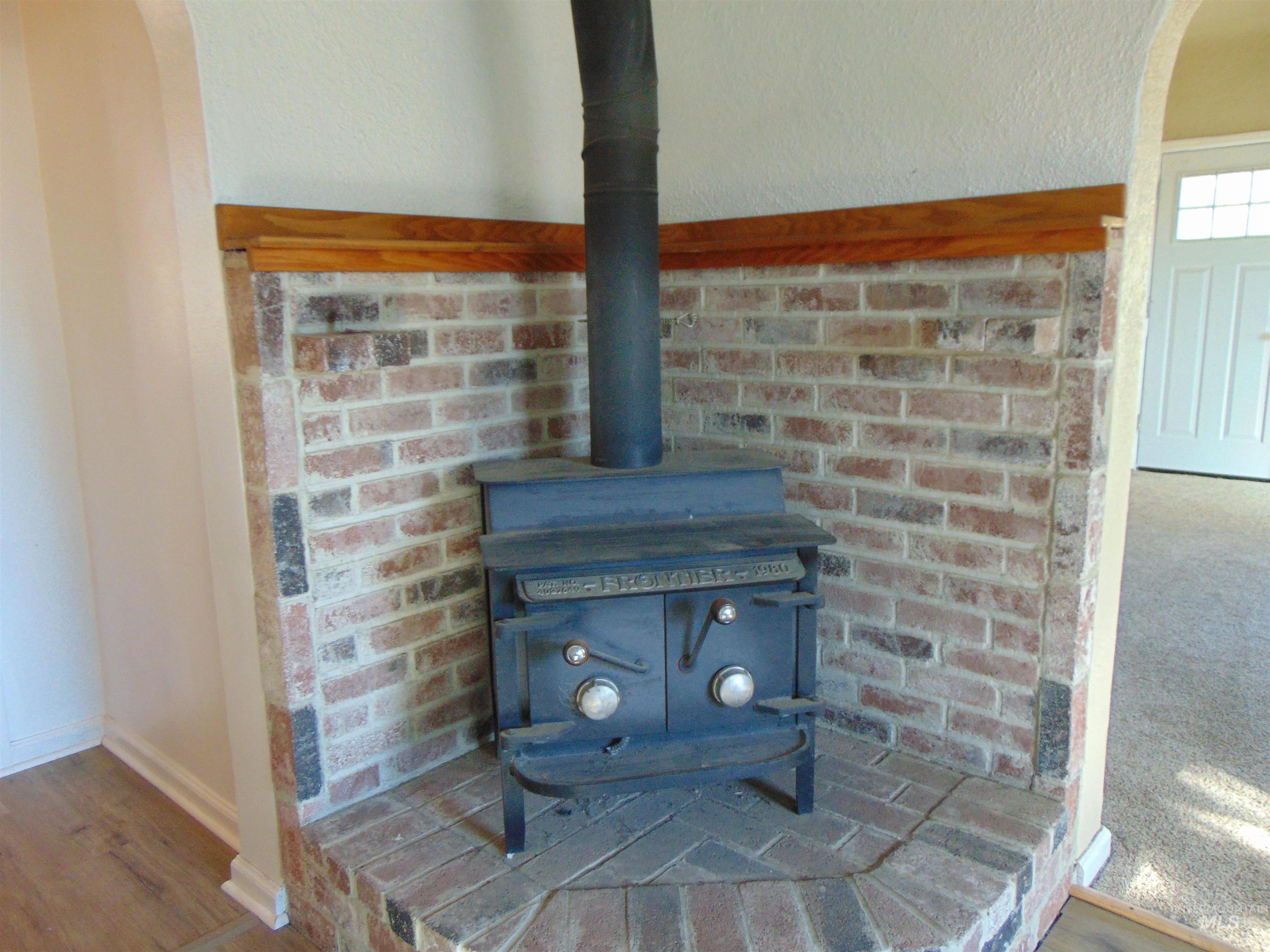 Detailed view of arched walkways, a wood stove, and wood finished floors