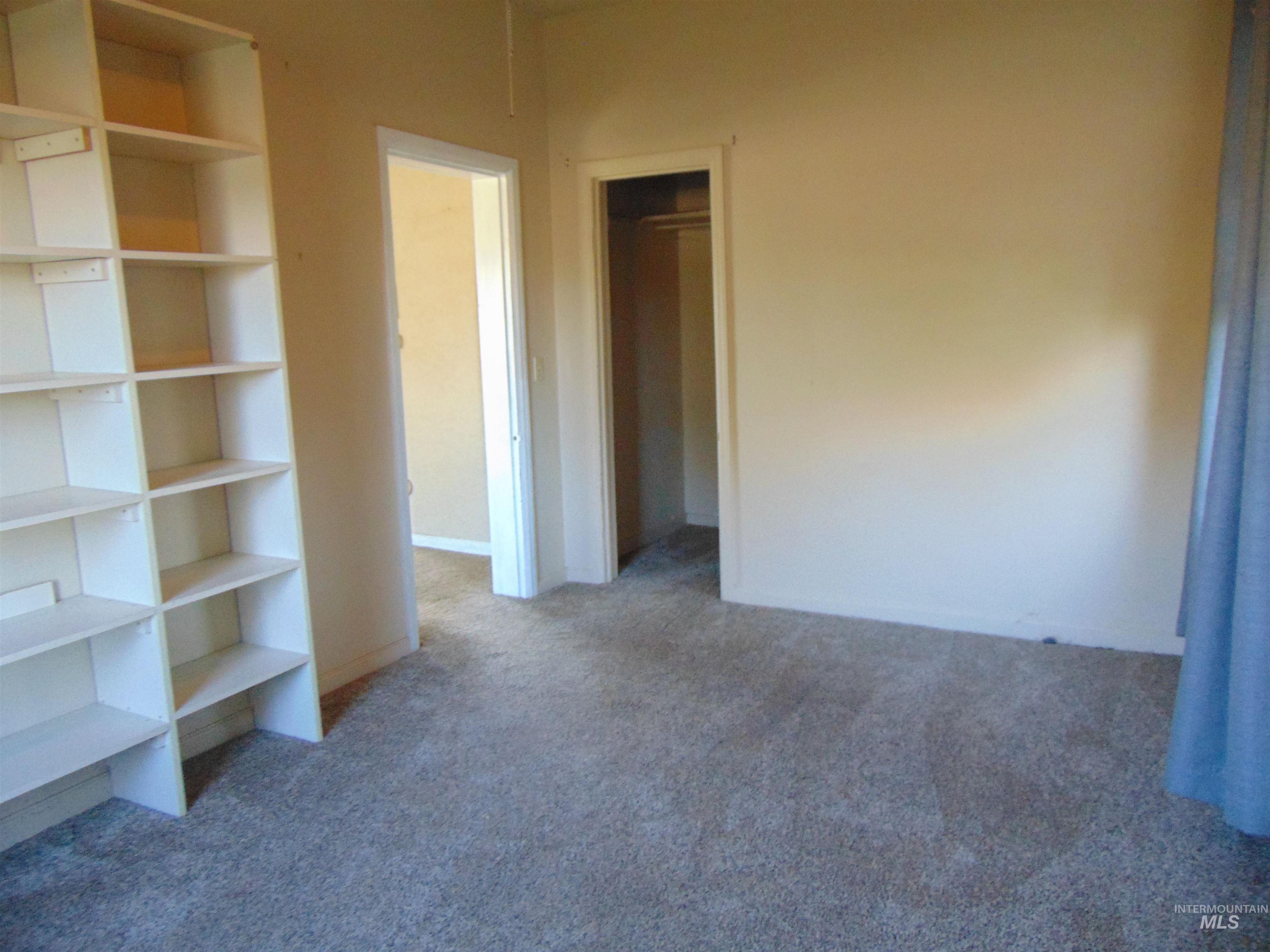 Unfurnished bedroom featuring light carpet and a closet